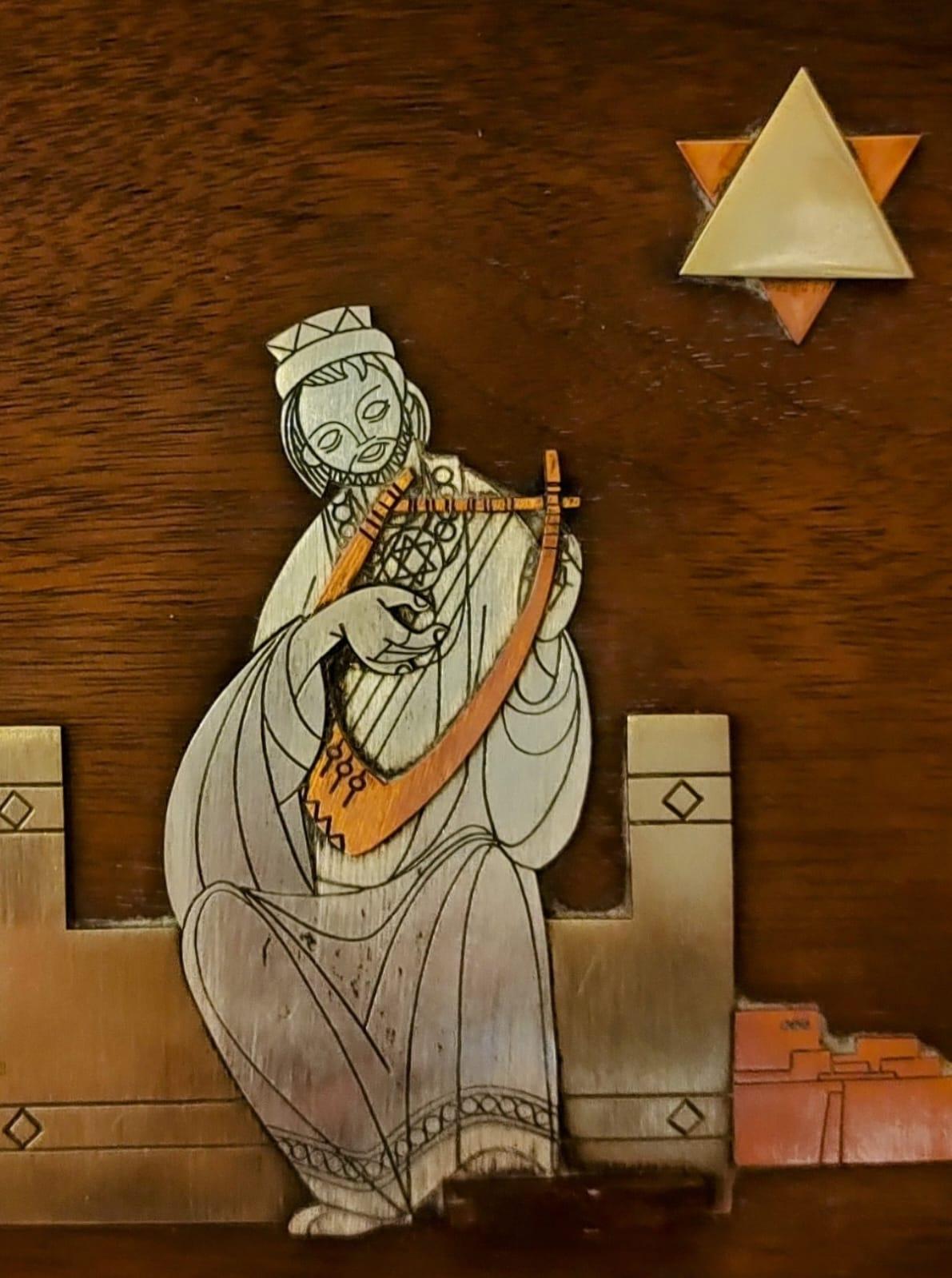 Pièce décorative stylisée très bien conçue représentant le roi David jouant de la harpe avec les murs et les bâtiments de Jérusalem suggérés dans les éléments en arrière-plan. Le travail combine très harmonieusement le cuivre, le laiton et l'argent