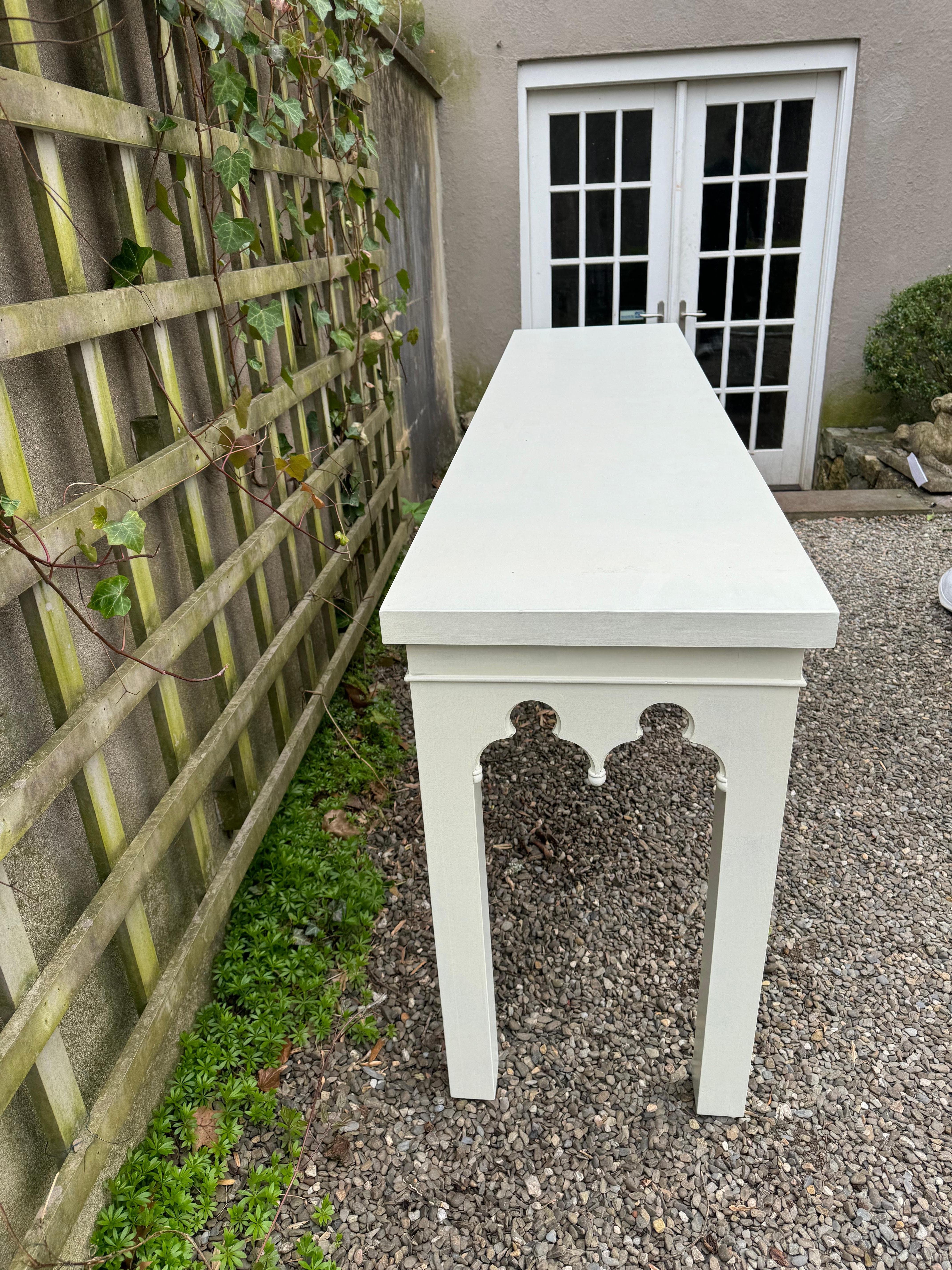 Beautiful well made heavy painted white wood rectangular console table  having decorative scalloped cut out apron.