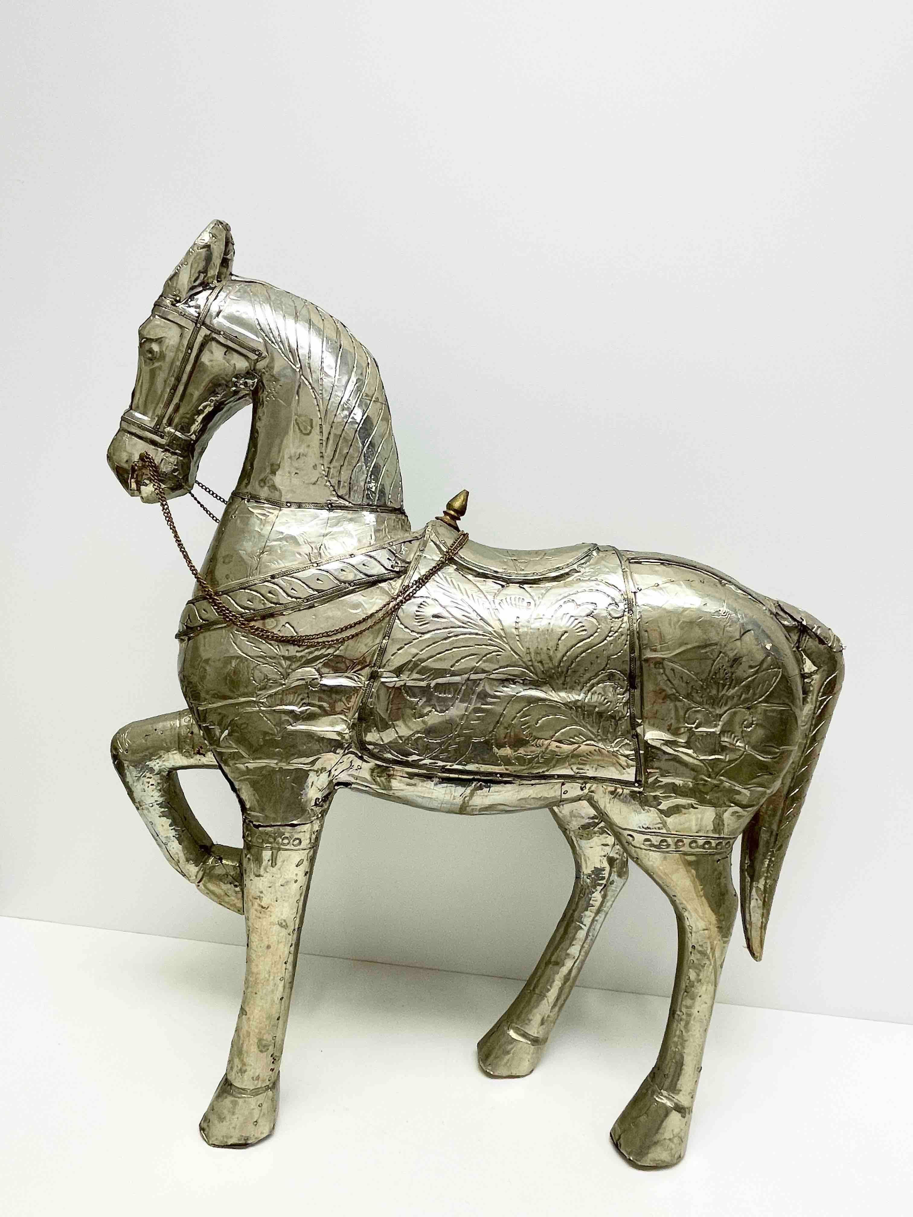 A beautiful decorative horse statue. Some wear with a nice patina, but this is old-age. Wooden horse coated with metal. Very decorative and nice to display in your library or any room.