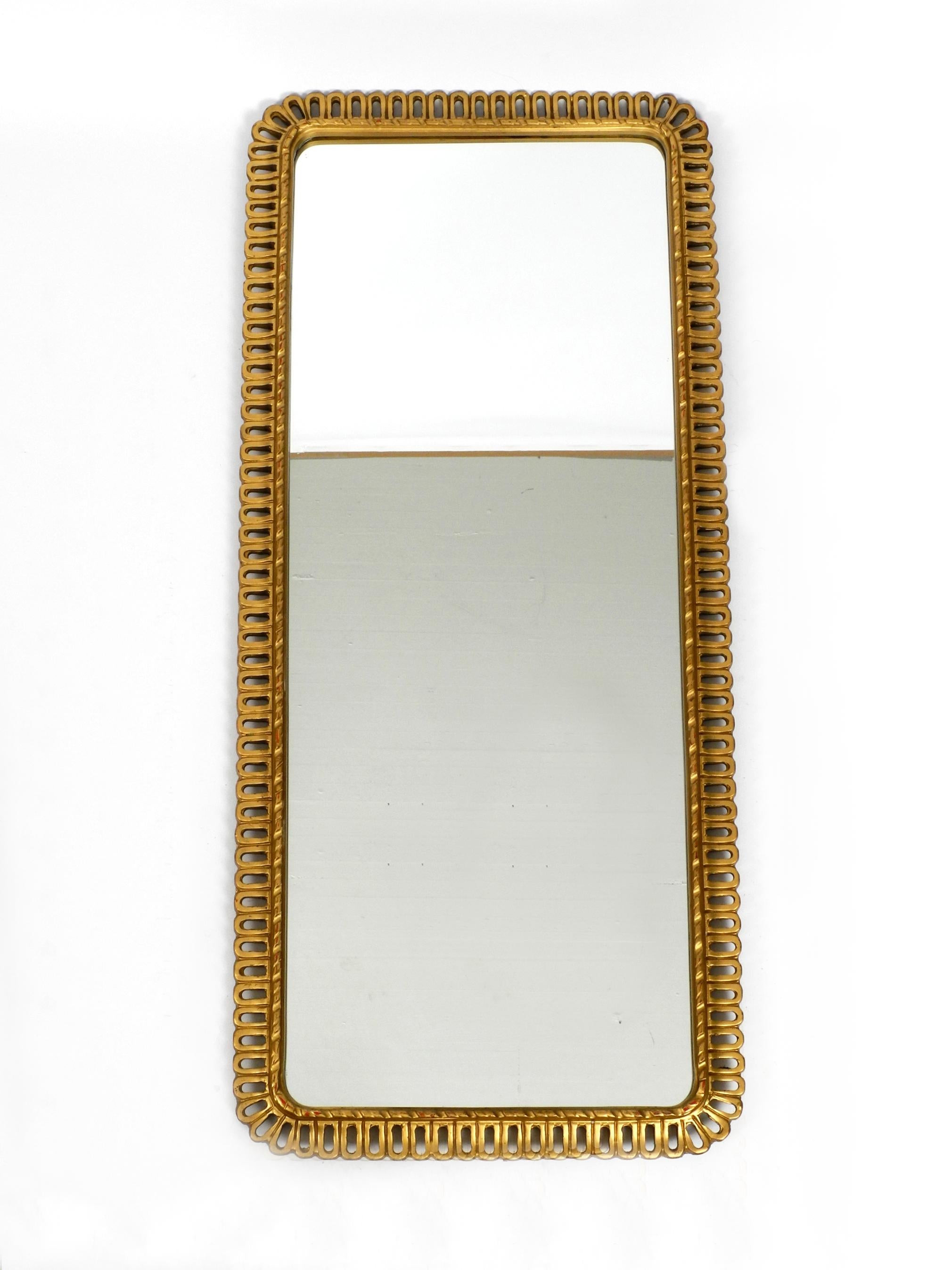 Rare beautiful long large wall mirror with high quality wooden frame.
The whole frame is gilded. Very high quality manufactured 
by Schöninger Spiegel, Germany. Great 1950s design.
Very good vintage condition without damage with fantastic