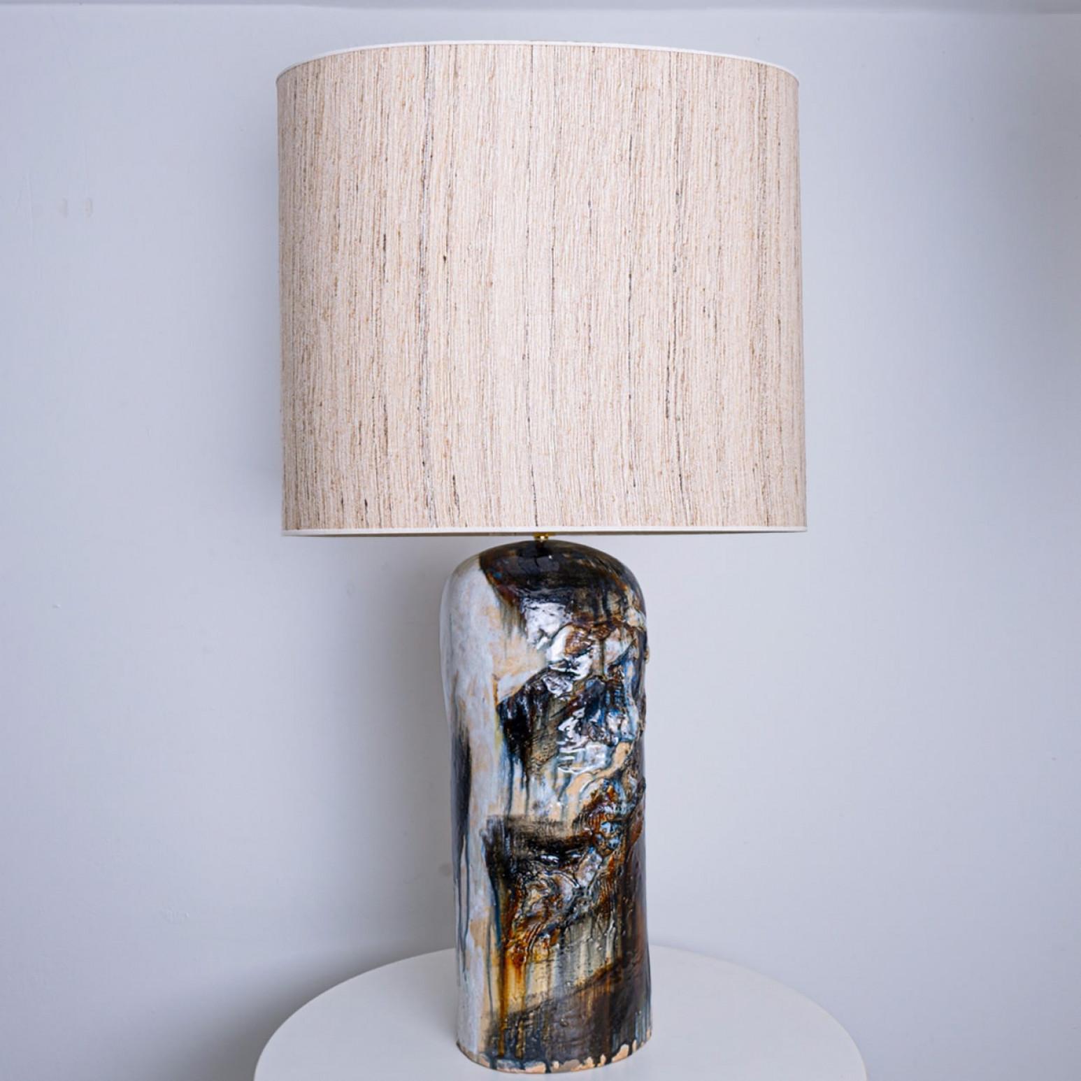 Beautiful floor table lamp by Jeppe Hagendorn, Denmark 1960s.

This stunning lamp has a ceramic base with earthy and blue tones and a beautiful glaze, making it a real eye catcher and a statement piece. The lampshade is designed by Rene Houben. This