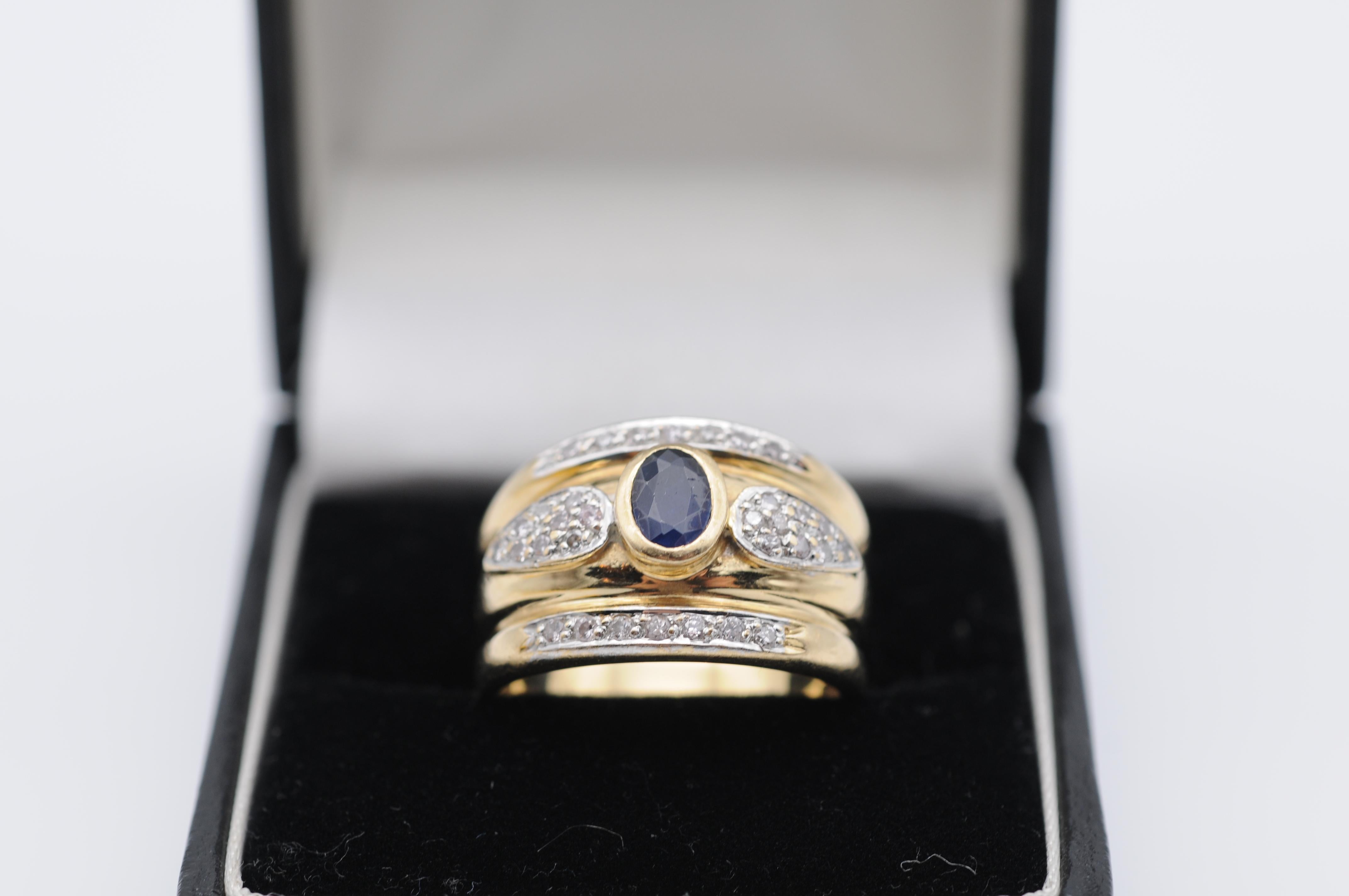 Indulge in the captivating allure of this exquisite 14k yellow gold ring, a true masterpiece of design and craftsmanship. At its center lies a mesmerizing dark blue sapphire, carefully cut into an exquisite oval shape that radiates a sense of