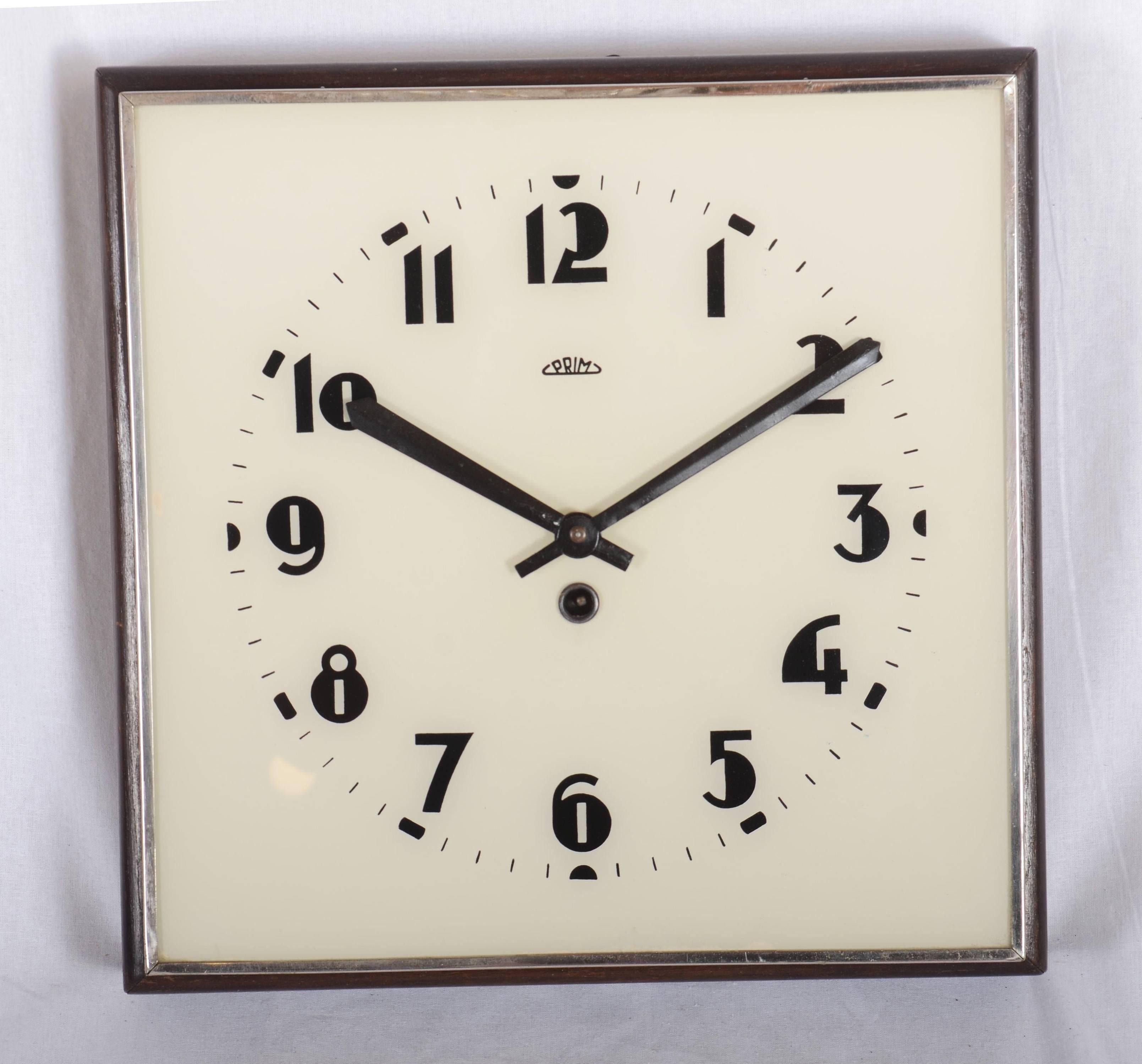 Wooden frame with white glass and black digits caught in steel, made by Prim in the 1930s. The original movement ware changed to an electric one powered by a small battery. Delivery time 2-3 weeks.