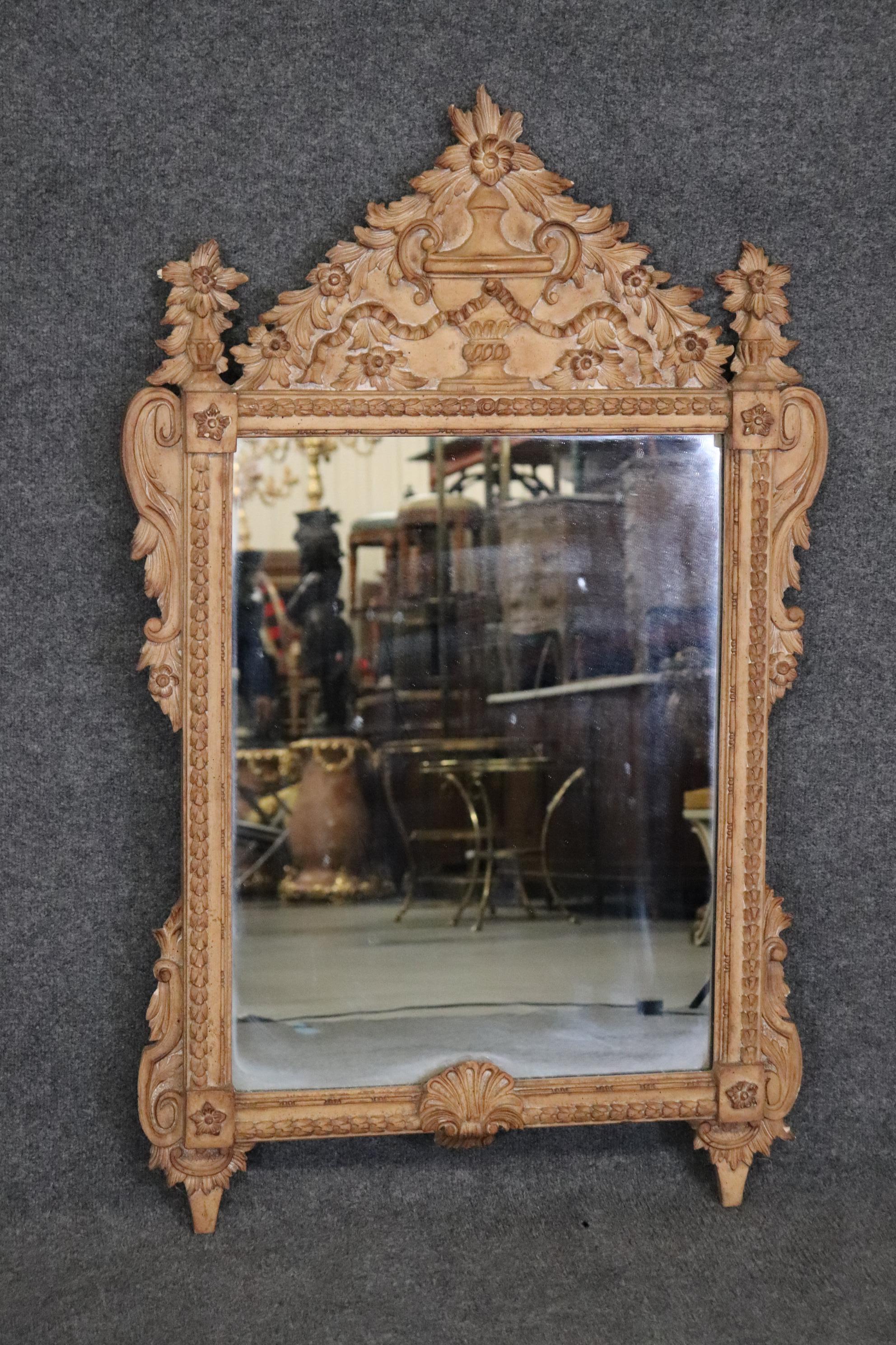 Ce miroir en noyer massif est magnifiquement sculpté de motifs floraux et de feuillages, dans un style Louis XV. Le miroir date des années 1970 et mesure 46,75 de haut x 29,5 de large x 2 pouces d'épaisseur. Bon état. 