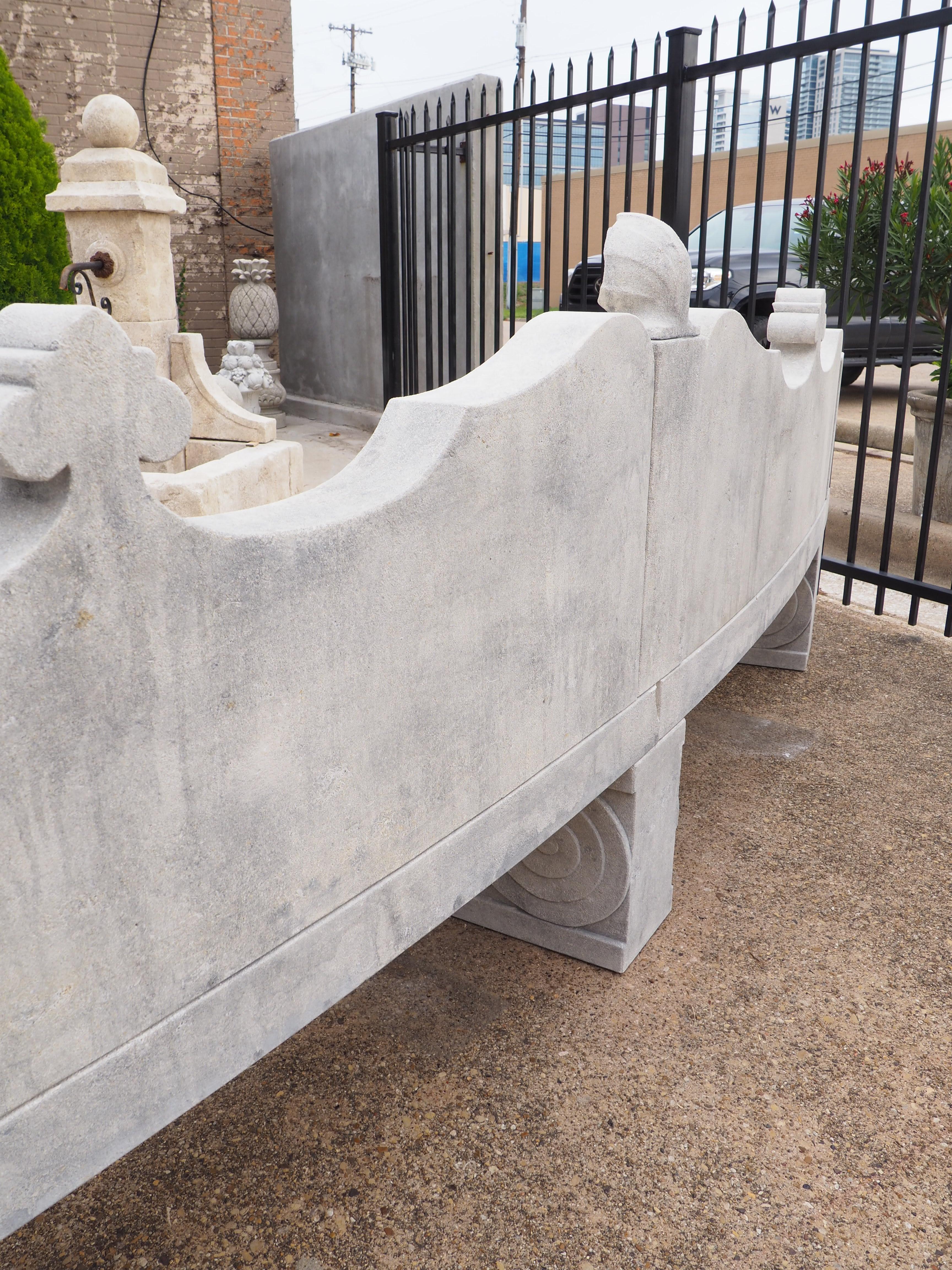 This beautiful garden bench consists of 10 limestone pieces that have been hand-carved by a skilled Italian stone mason. The sinuously shaped back has volute scroll elements with two fleur de lys points flanking a central scalloped shell finial.