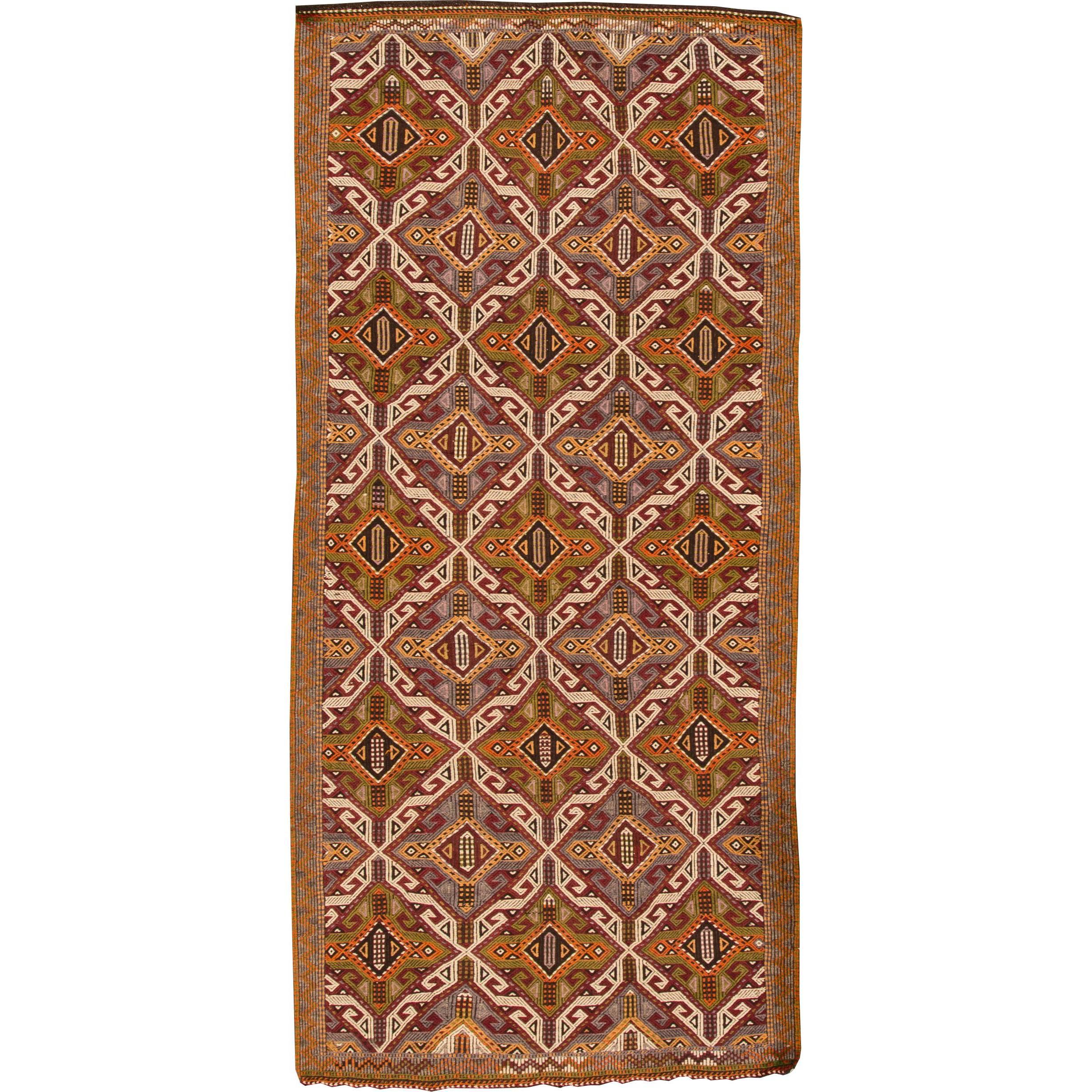 A hand-knotted Sumahk rug with a geometric design on a brown field. Accents of orange, beige and green throughout the piece. This rug measures 4'.11 x 10'.6.