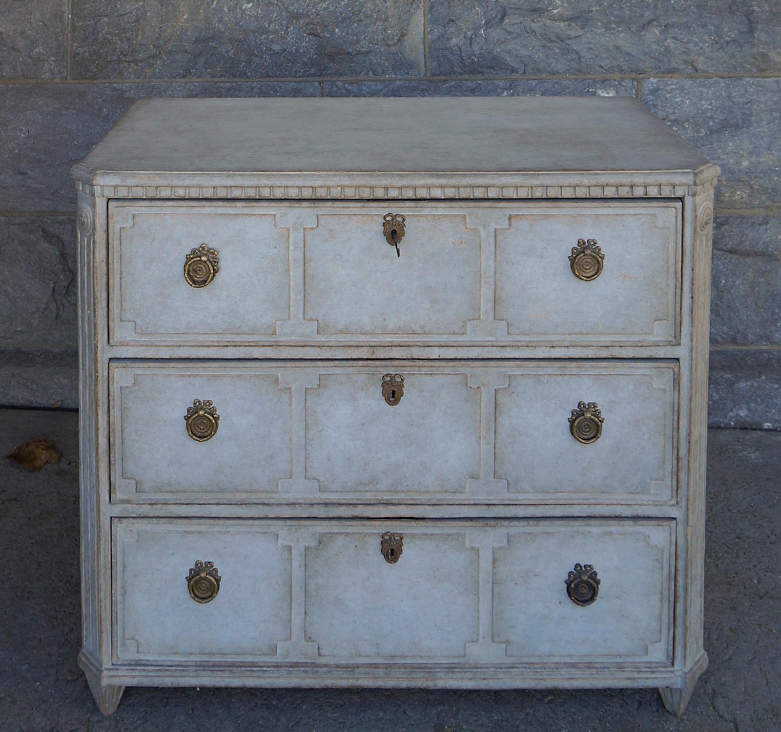Swedish chest of drawers, circa 1870, with dentil molding at the top and canted corners with rondels and reeding. The drawer fronts each have three raised panels with notched corners, all inside a raised border. The hardware has been replaced.