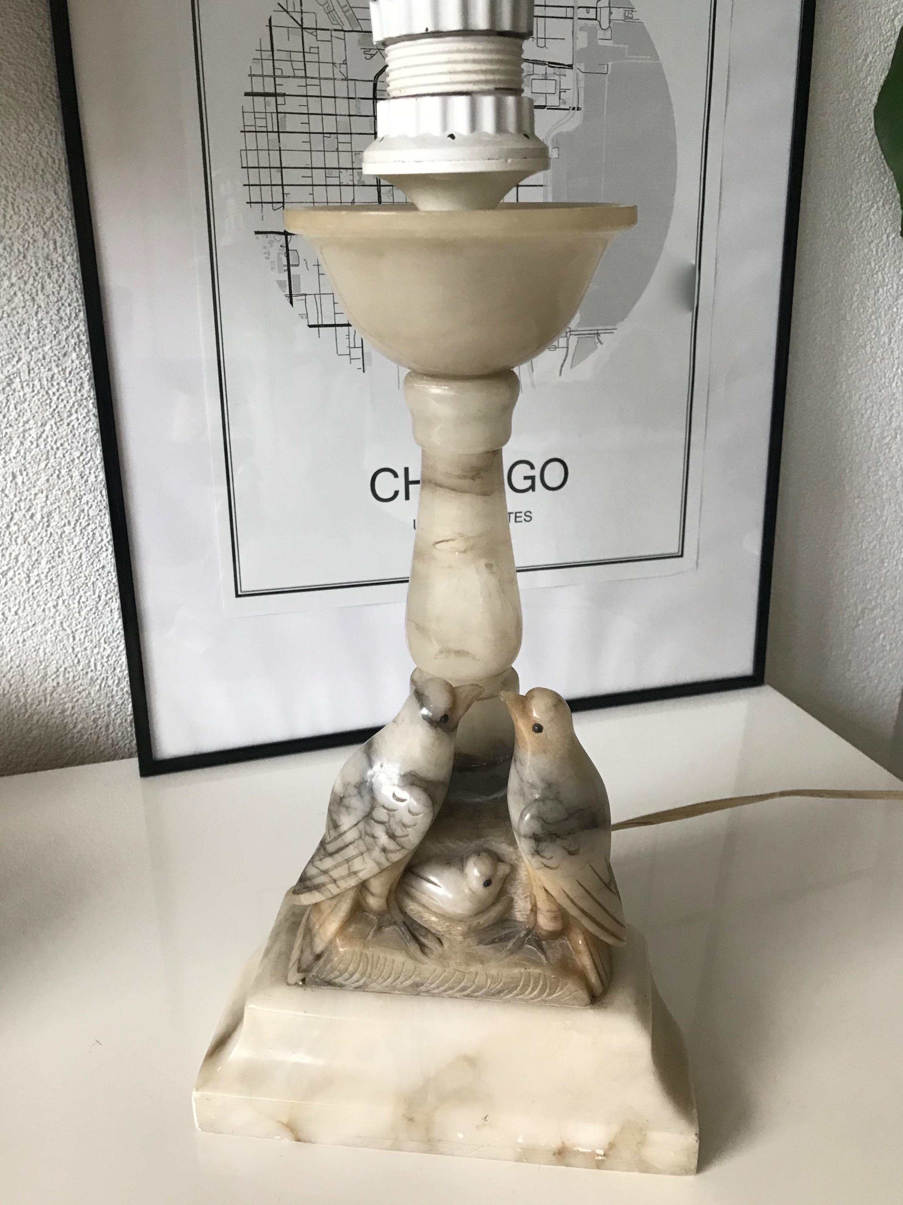 Excellent condition sculptural alabaster table lamp from the 1950s.

This highly decorative and practical size table lamp is the type of applied arts that really lifts your spirit. The birds sitting by their nest with young, is an absolute joy to