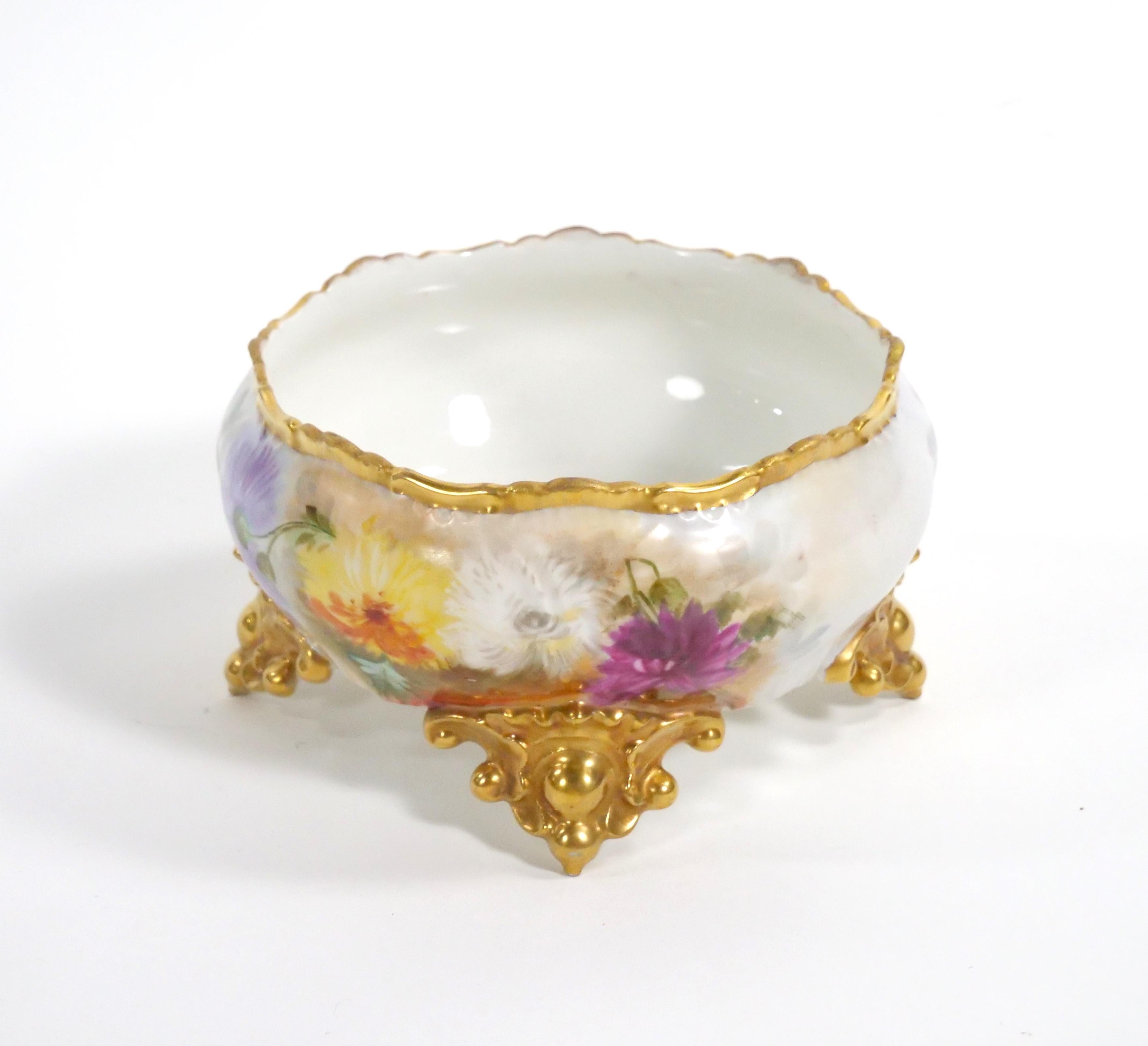 Enhance your dining or decor with this beautifully hand-painted and gilt gold-decorated French Limoges Porcelain Footed Tableware Centerpiece Bowl. This exquisite piece is a true work of art that radiates elegance and charm. The centerpiece is