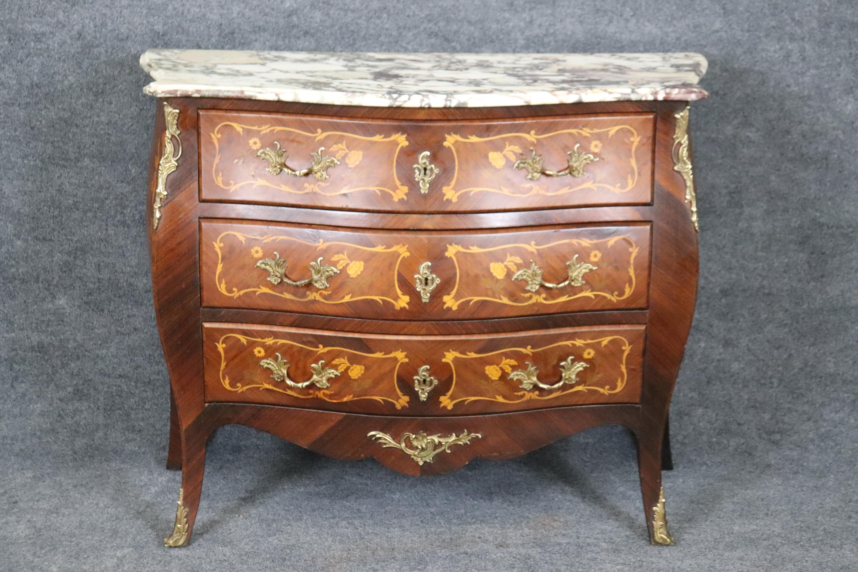 This is a gorgeous inlaid walnut and satinwood floral and bronze mounted commode. Look at the quality of the inlay and marble top. The bronze mounts are nice and crisp. Good original finish and conditon. Measures 46.25 wide x 20.25 deep x 36.5 tall.