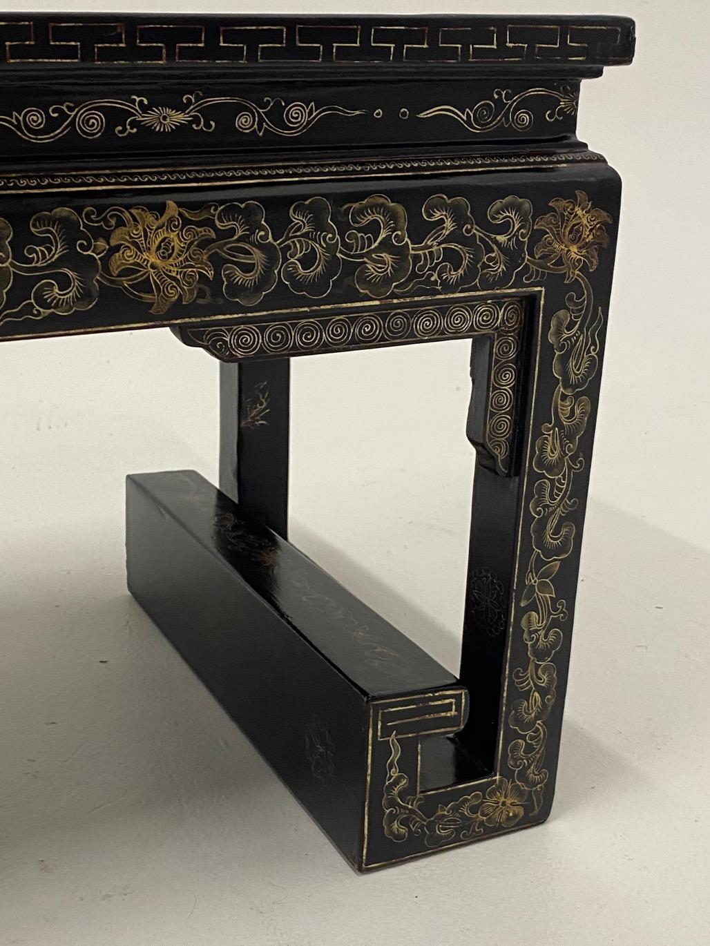 Beautiful Chinese black lacquer cocktail table having a fabulous shape and meticulous decoration in gold.