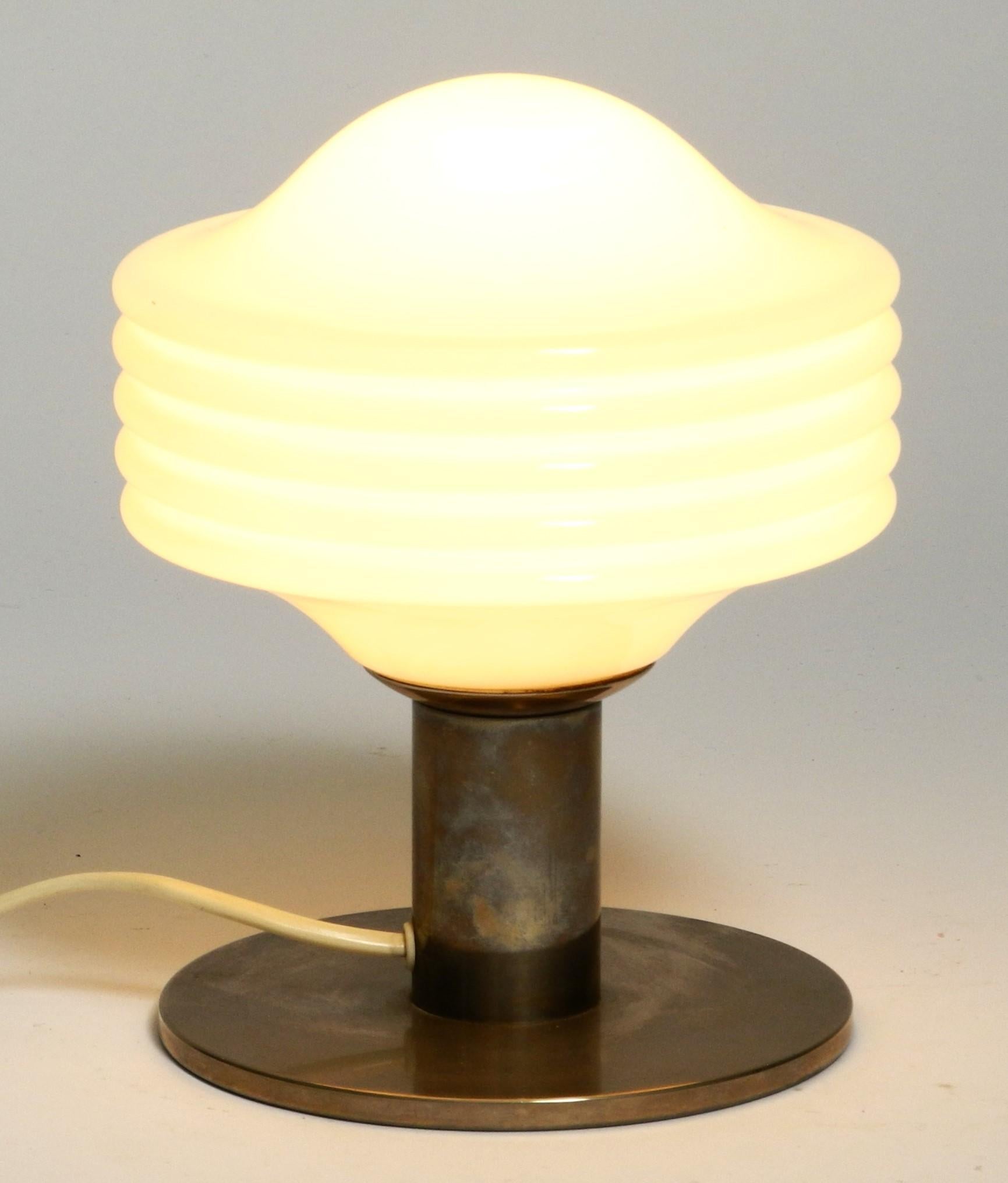 Pretty little Space Age table lamp from Temde Leuchten, Switzerland 1970s.

The lamp has a heavy chrome-plated lamp base and a glass shade made of opal glass. The chrome plating is tarnished and gives the lamp a beautiful patina. 

No damage, fully