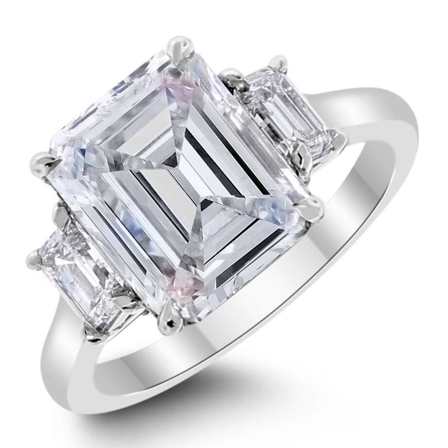 The clean defined lines of this 3 diamond Emerald Cut engagement ring are reflection of strength and power. The VVS2 clarity center diamond reflects uncompromising purity and brilliance. 

Center Diamond Shape: Emerald Cut  
Center Diamond Weight: