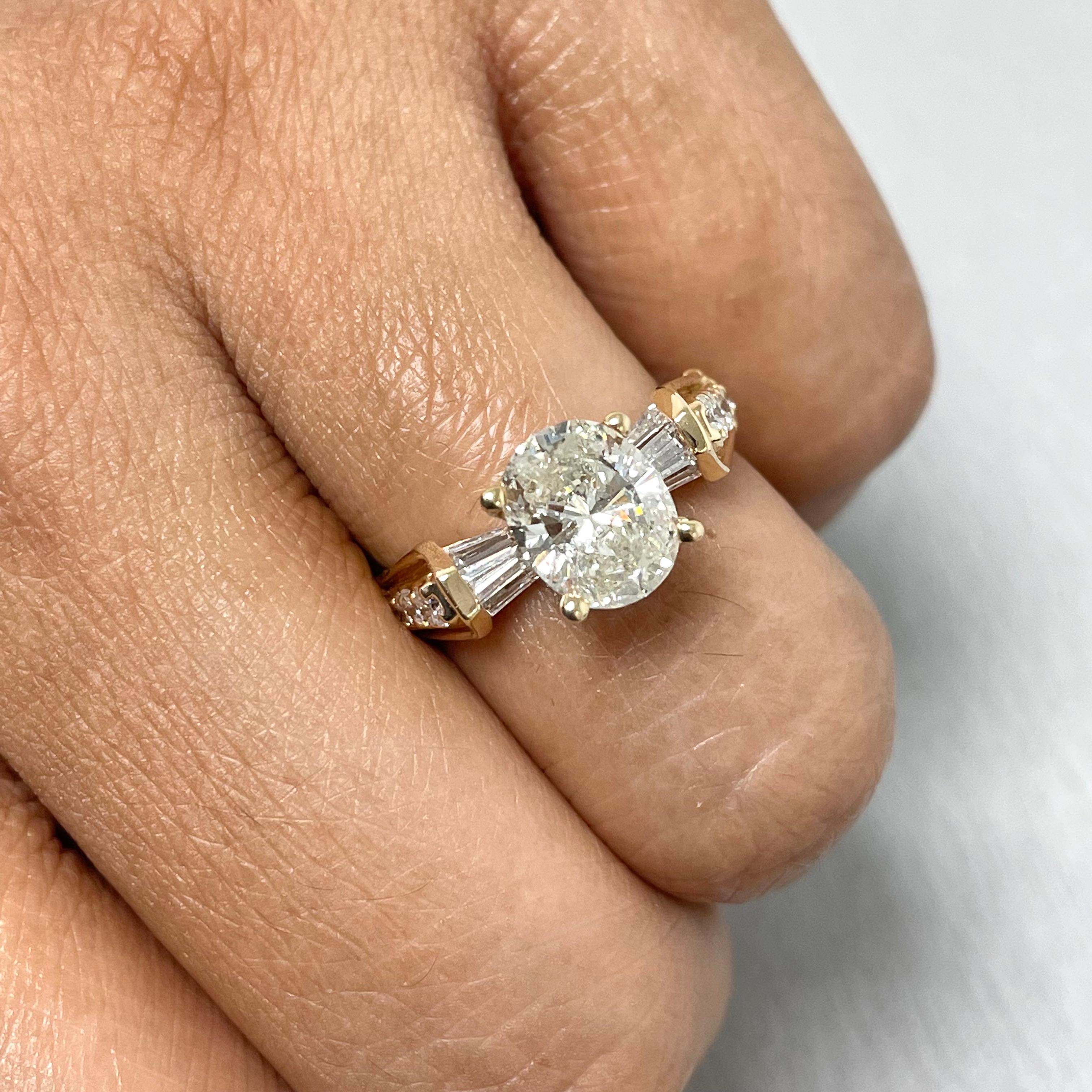 Chic and delicate, this Oval solitaire engagement rings features uniquely set baguette diamond accents spanning the face of the ring with round diamonds on the side shank.

Center Diamond Shape: Oval
Center Diamond Weight: 1.62 ct 
Diamond Color: J