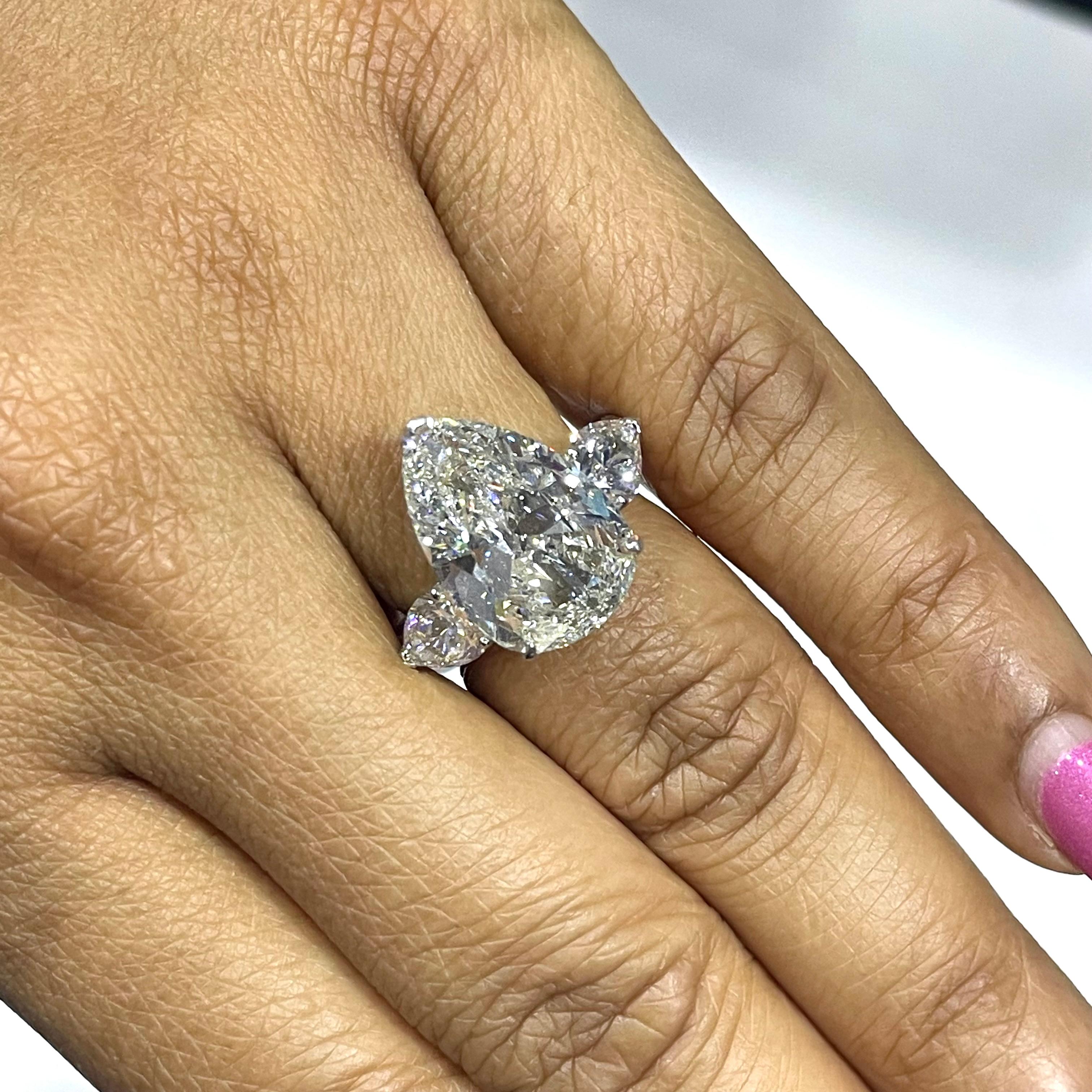 A timeless and enigmatic 3 stone ring, the Diva Ring showcases a stunning larger than average 6.64 ct pear shaped diamond flanked by 2 additional pears to the side. With a depth of 53.4 and measurements of 16.59 x 11.07, the center solitaire looks