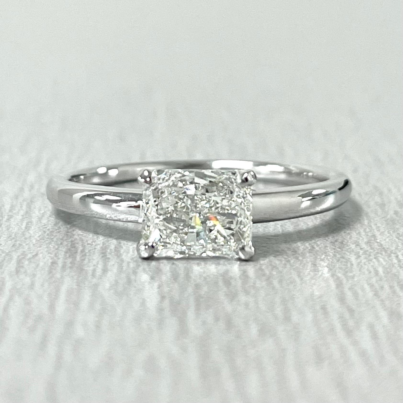 This stunning 1.01 Carat Radiant Cut HVS2 Solitaire Ring is all the bang for the buck. With larger measurement and stunning fire and luster, it is a dazzler. The East West Set Diamond gives the ring a modern and chic flare making it the perfect
