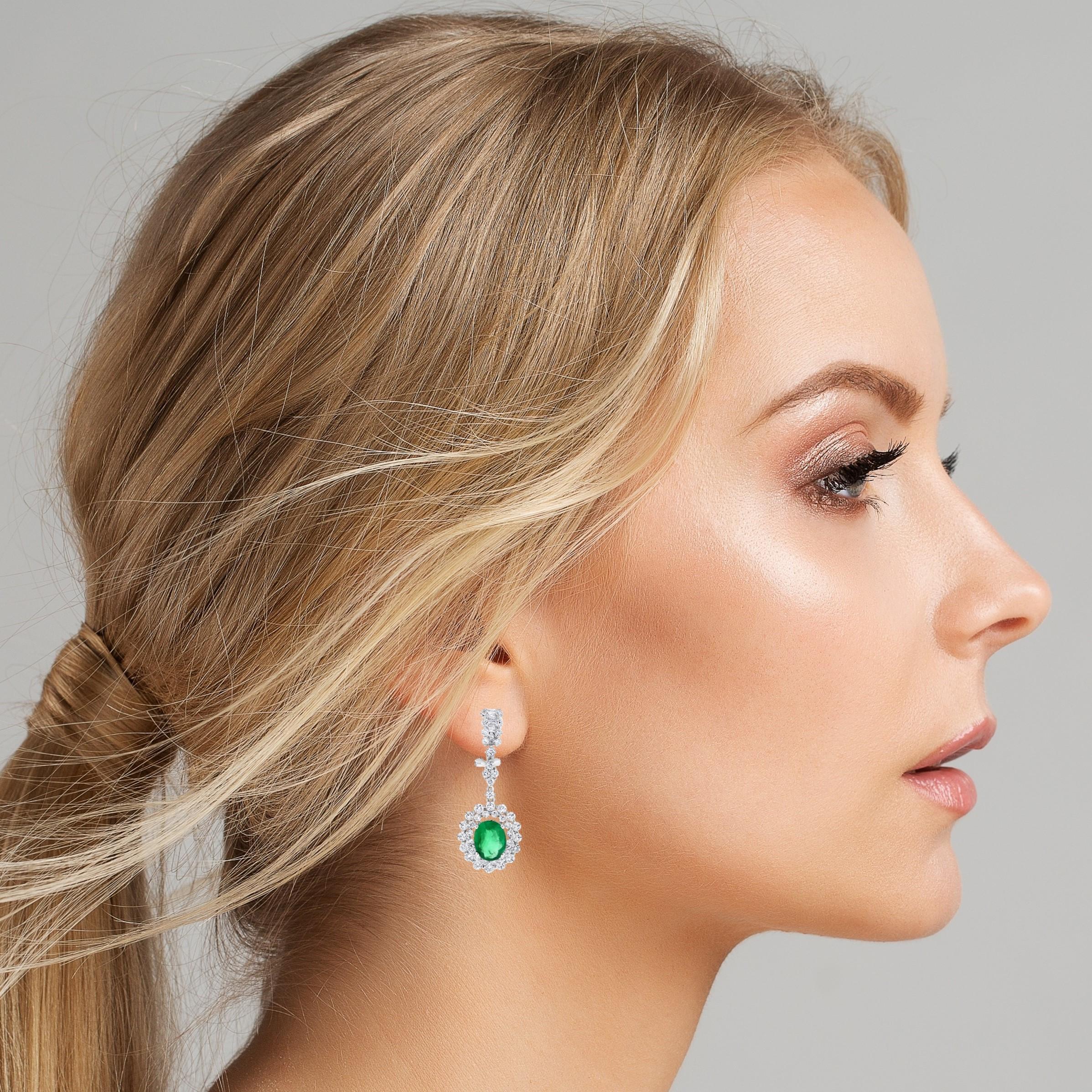 With warm green emeralds set in a cool diamond halo, dangling from the ears, the Gina earrings are perfect for a summer soiree or a winter party. 

Gemstone Type: Emerald 
Gemstone Shape: Oval 
Gemstone Weight: 3.60 ct 
Gemstone Color: