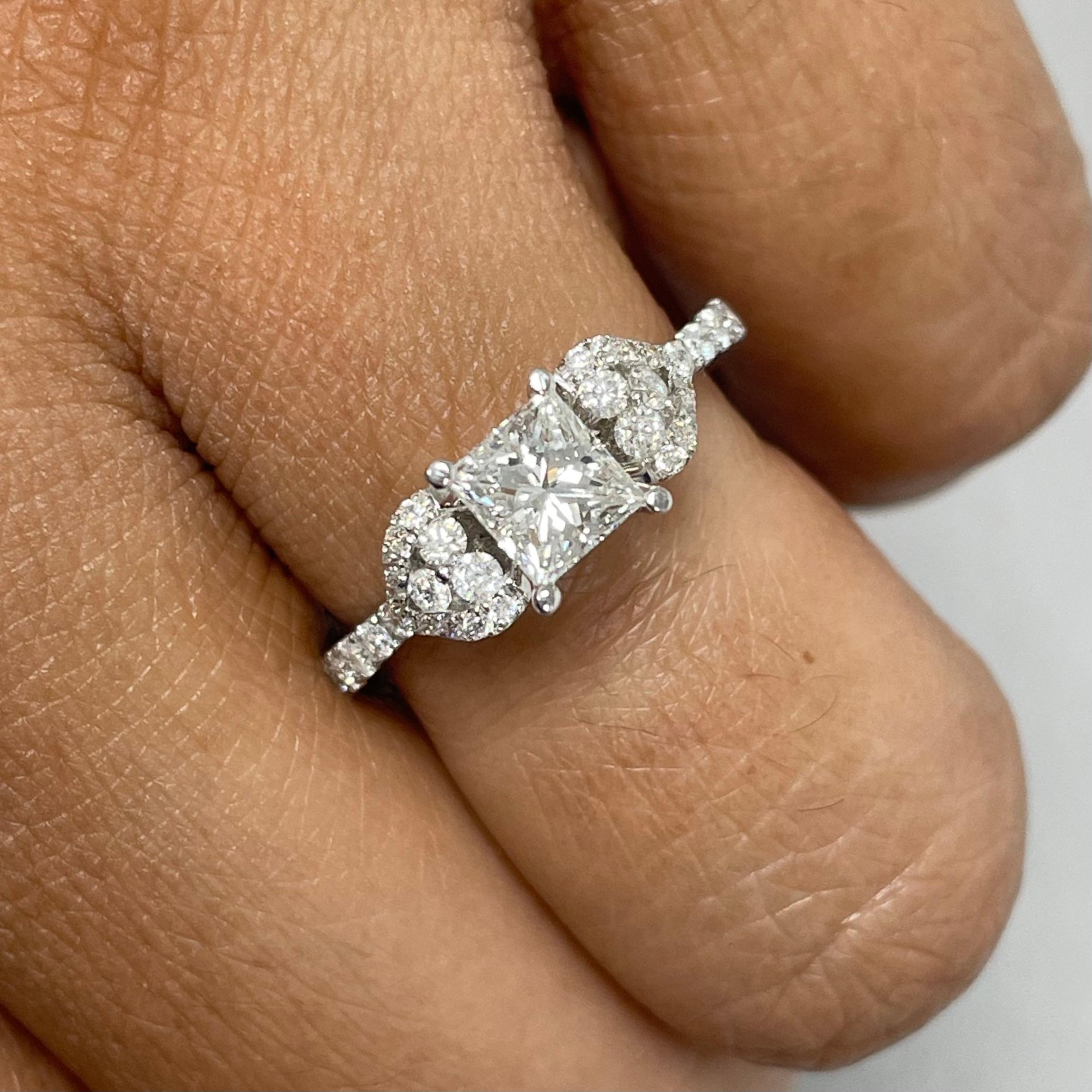A testament of young love, this Princess engagement ring with heart like accents is symbolic of  promise and commitment. 

Center Diamond Shape: Princess Cut 
Center Diamond Weight: 0.71 ct 
Diamond Color: G 
Diamond Clarity: VS 

Side Diamonds