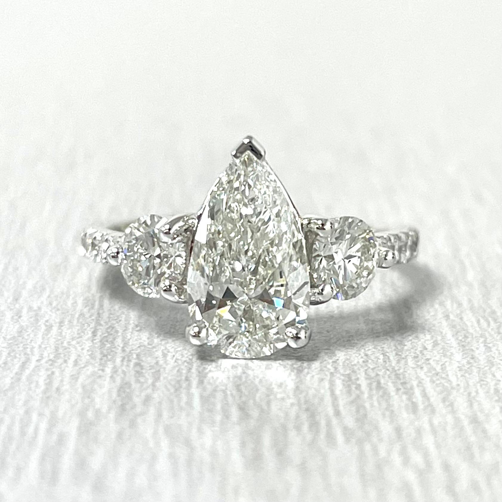Featuring a 1.50 ct ISI1 GIA Pear Shape that measures like a 1.75 ct gorgeously flanked by matching 0.30 ct GIA ISI1 certified rounds, the Reina Engagement Ring is a fire cracker.

Center Diamond Shape: Pear Shape
Center Diamond Weight: 1.50 ct
