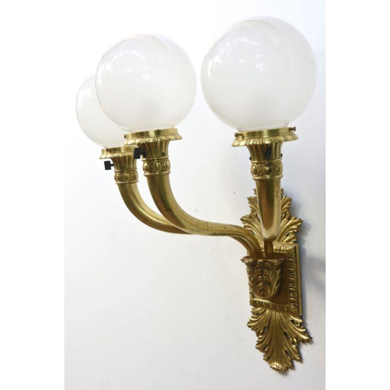 Early Electric, Exceptional Cast Brass Sconces. Greek revival styling. square backplate with fans of acanthus leaf castings pointing up and down. tapered round arms with classical column crowns. Glass ball shades with interior sandblasting. These