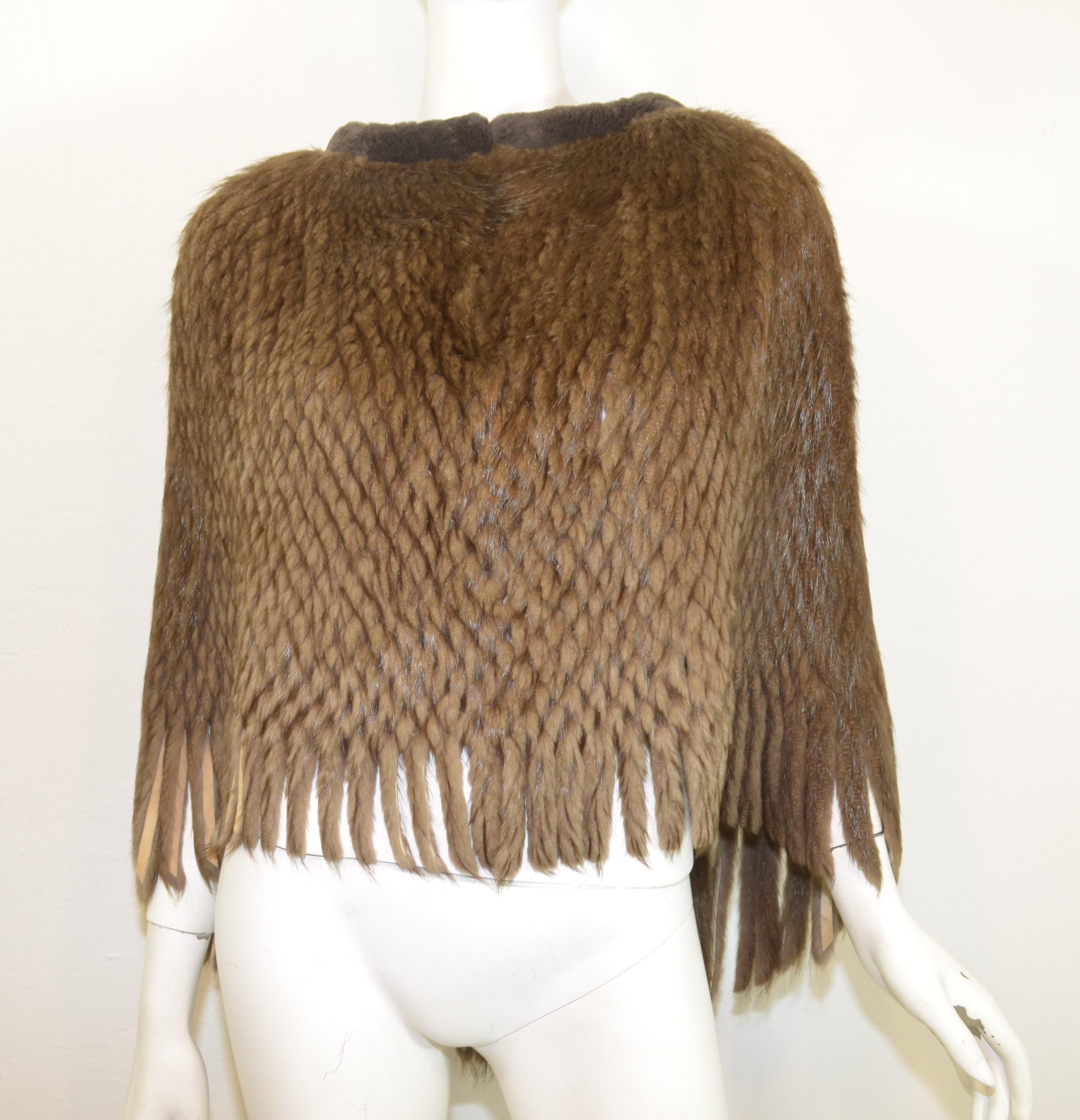 Beaver fur knitted cape features long beaver fur knitted throughout with a sheared mink collar and fringed hem. 

Measurements:
length 27'', opening 54''