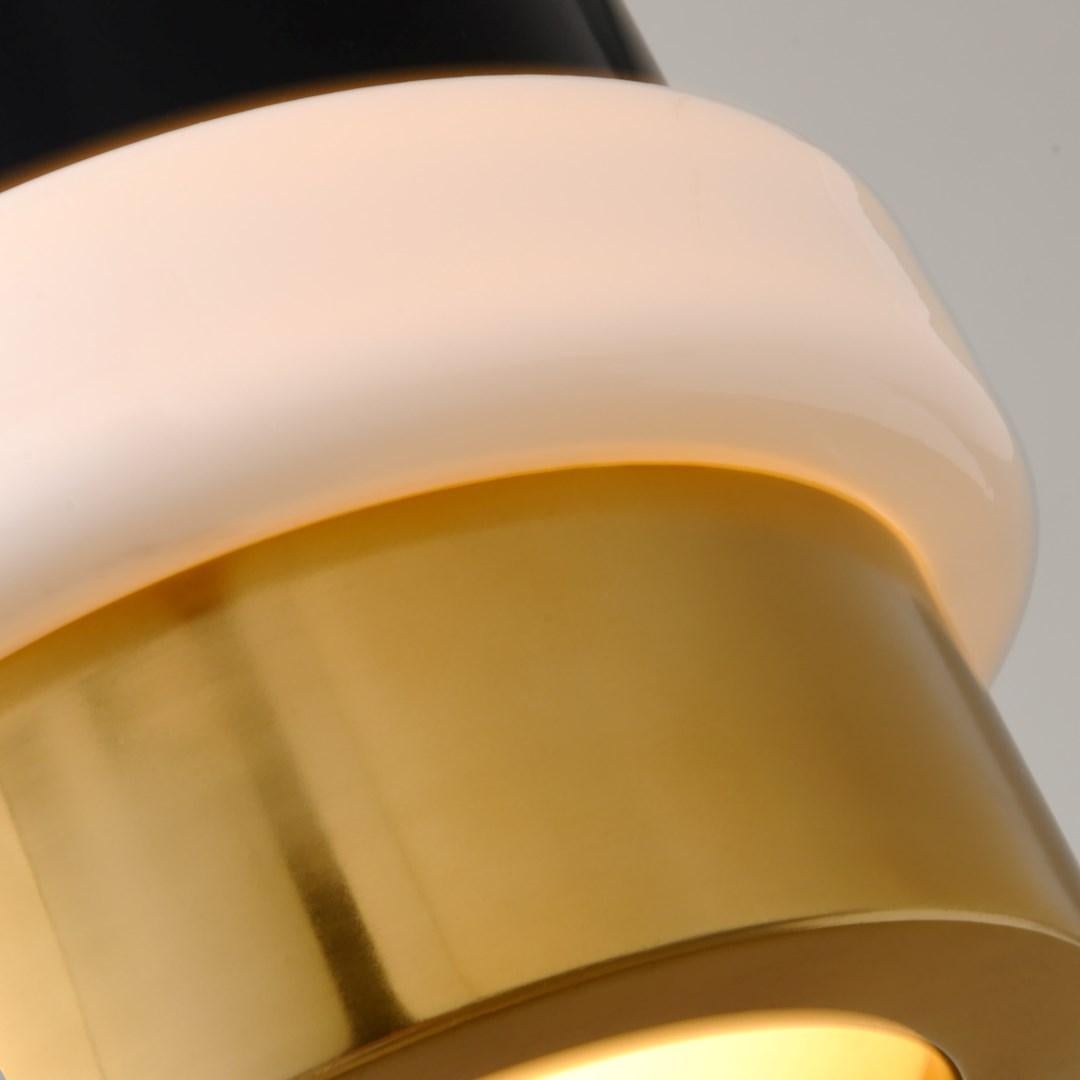 Martyn Lawrence Bullard for Corbett Lighting
Sleek tubular style and metallic sheen, ideal for contemporary interiors. 
Features a large Solid Brass cylinder, with two finishes separated by a ring of White Opal Glass. 
In addition to visually
