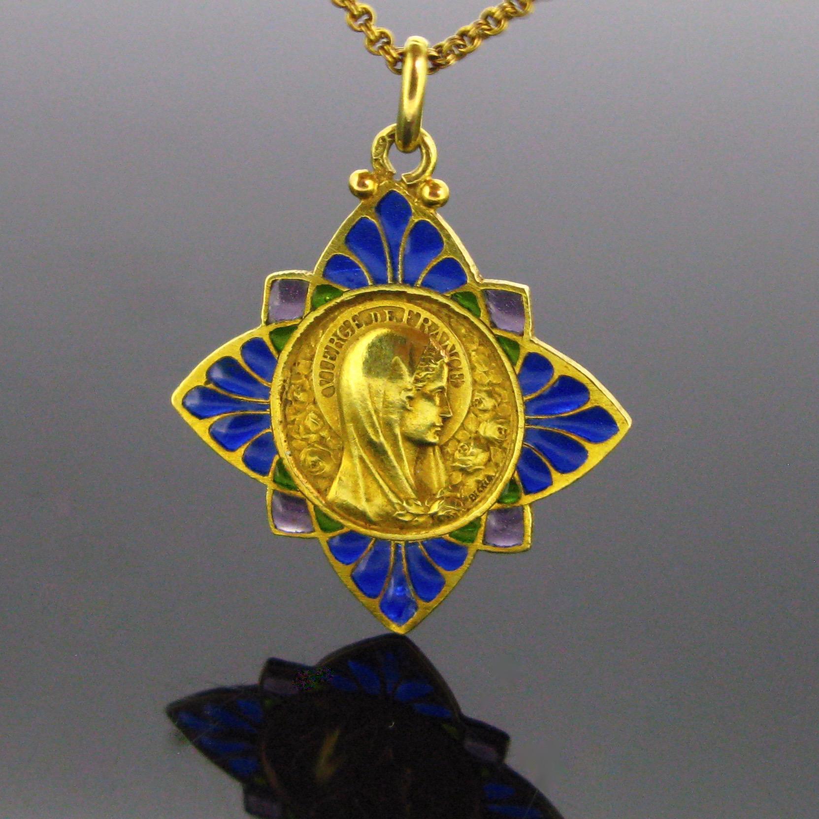 This beautiful medal from the Art Nouveau period is made in 18kt yellow gold and with navy blue, green and purple enamel, with the plique a jour technique. It features the profile the Virgin Mary saint to the right. She is surrounded with roses and