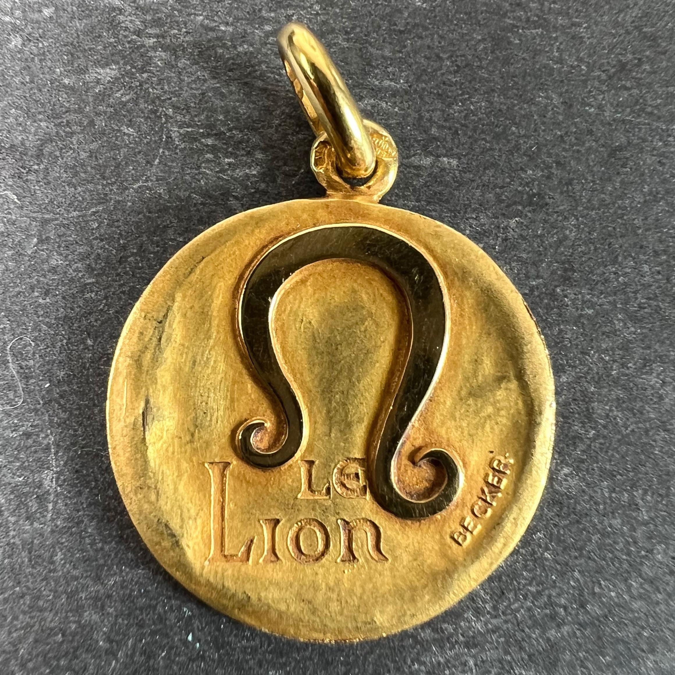 A French 18 karat (18K) yellow gold charm pendant depicting the Zodiac star-sign of Leo as the astrological symbol for the sign in polished gold on a matt gold convex recessed base, with the phrase 'Le Lion' beneath. Signed Becker and stamped with