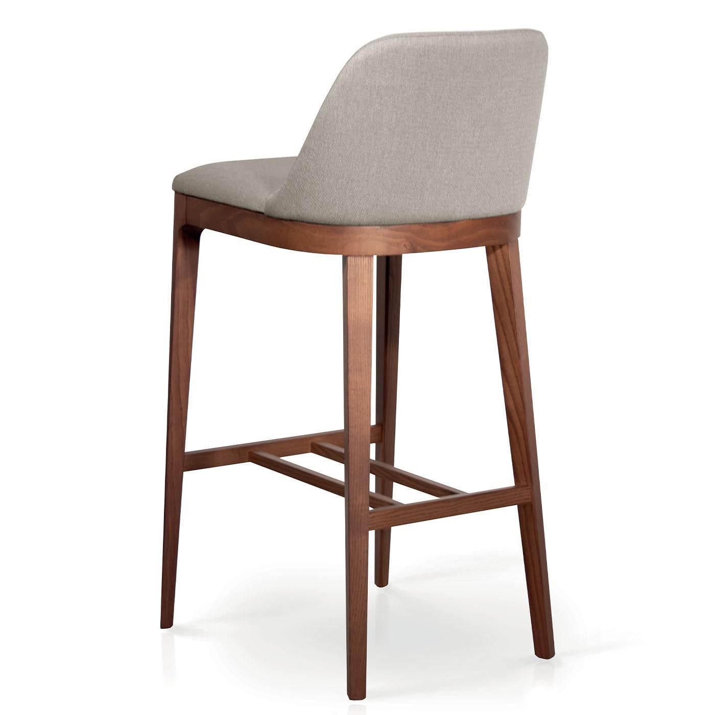 A clean and elegant design distinguished by softly rounded lines, this stool features a solid ash wood frame of simple yet rigorous geometry, supporting a softly padded seat with backrest, minutely covered with leather, faux leather, or fabric from