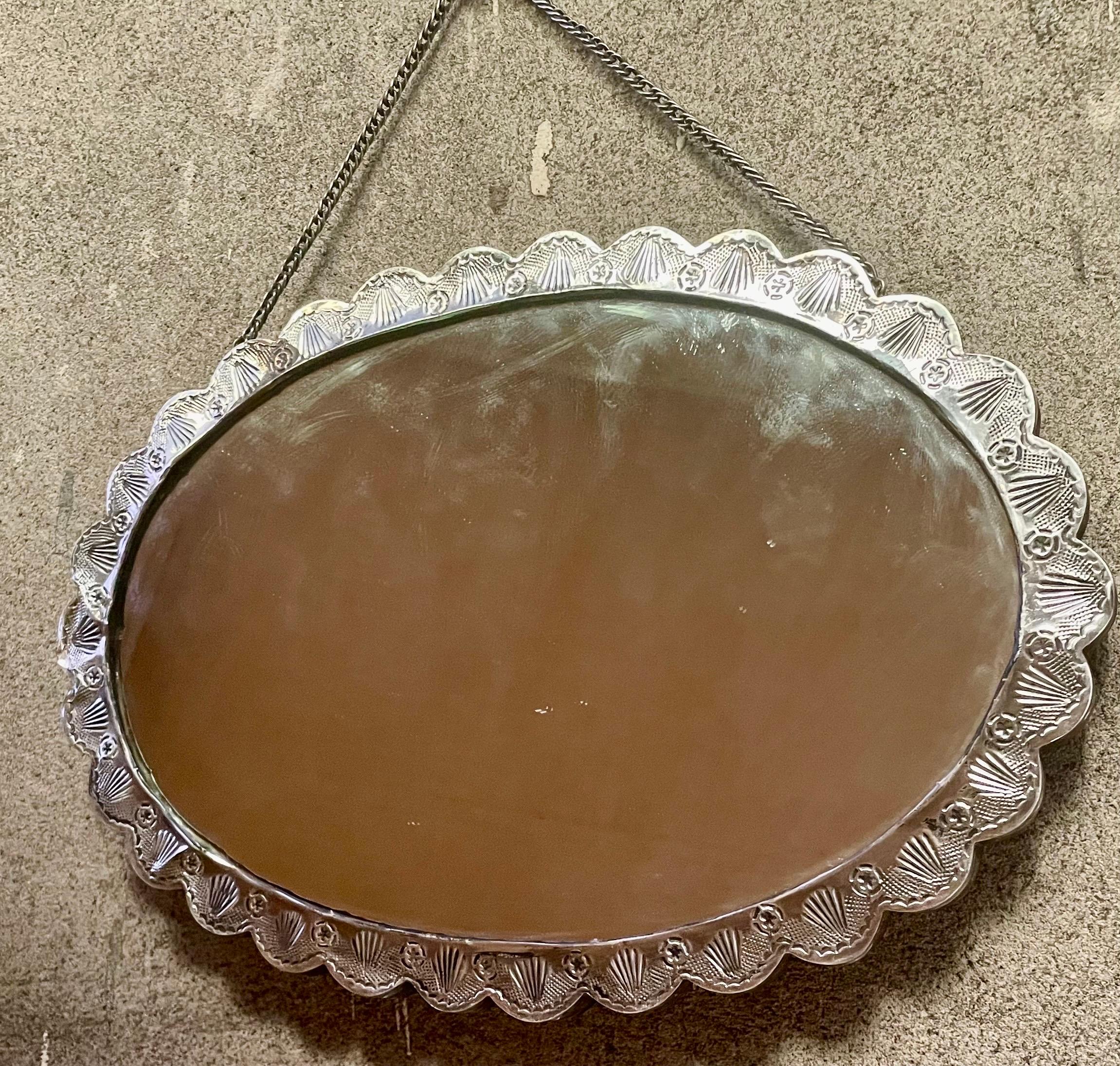 Si tratta di un fantastico specchio nuziale turco in argento 900 con impresso un fiore a 10 petali con centro ovale, tutto decorato con rose e foglie e circondato da conchiglie ripetute circondate da ferri di cavallo e altre forme. Il modello è