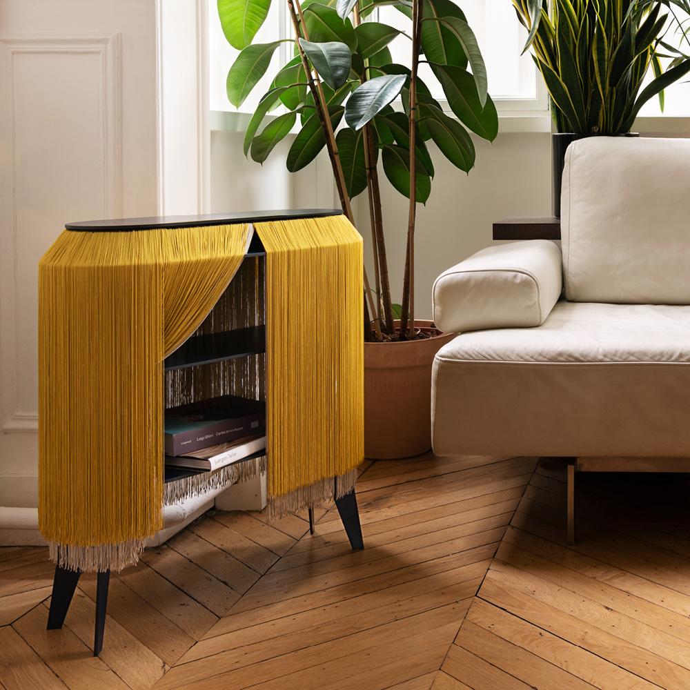 Baby Alpaga is distinguished by its long viscose fringes, offering a refined appearance reminiscent of a miniature boudoir on legs. This original bedside cabinet allows for discreet storage of secret objects behind these elegant fringes.

This