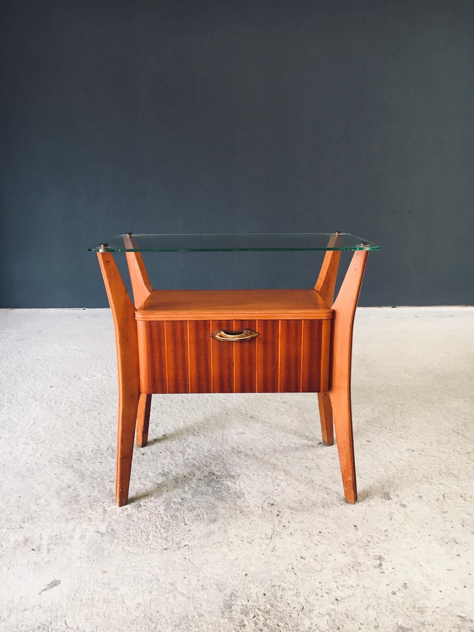 Table de chevet Vintage Midcentury Italian Design by Gio Ponti for La Permanente Mobili Cantu. Fabriqué en Italie au début des années 1950. Construction en bois de noyer et d'érable avec plateau en verre de cristal et poignée demi-lune en laiton.