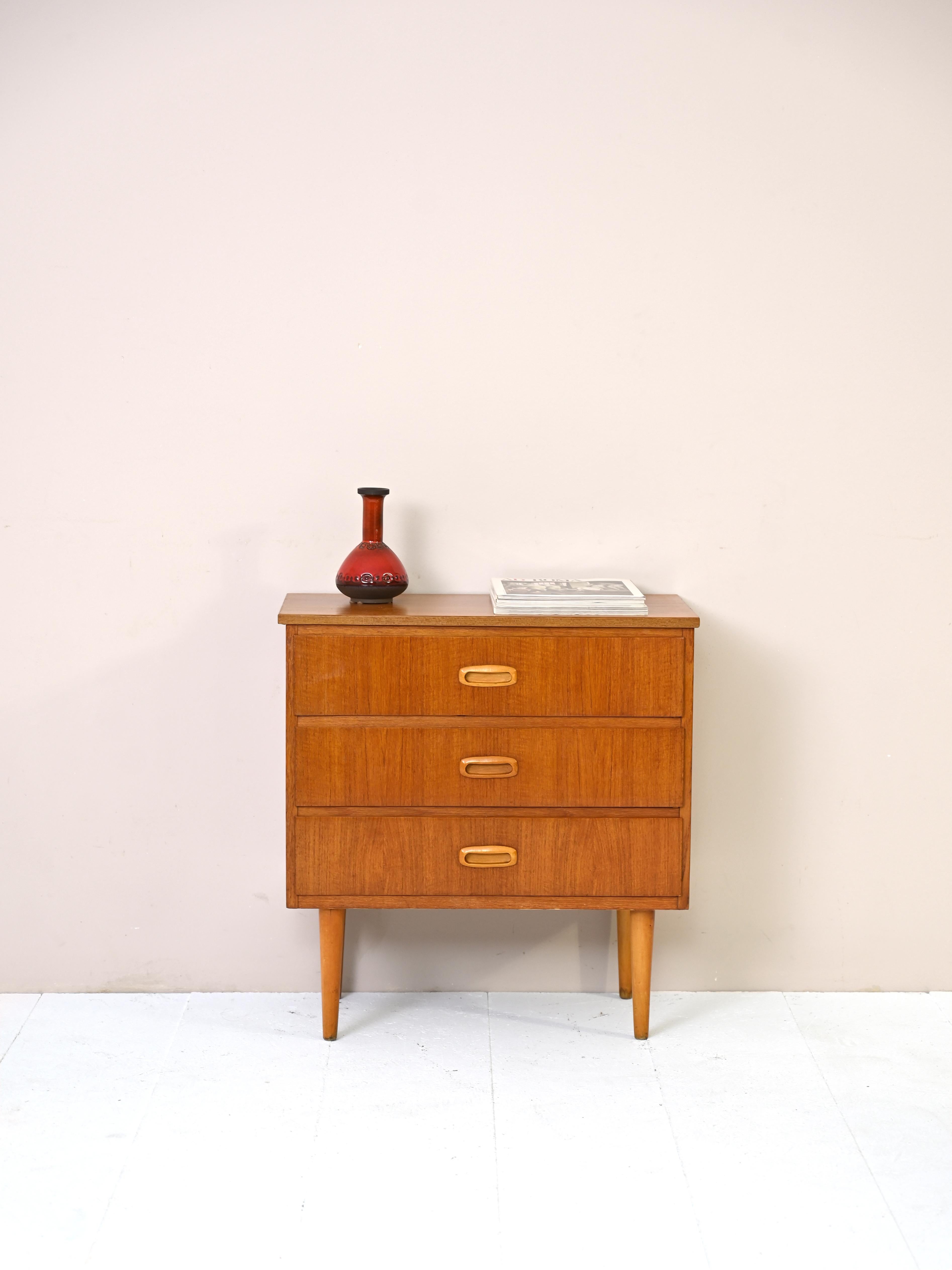 An original mid-century Nordic design furniture piece.
The teak wood frame is linear and uncluttered but enhanced by the wooden handle of the
drawers and the long tapered legs.
A piece of furniture that can be used both with the classic function