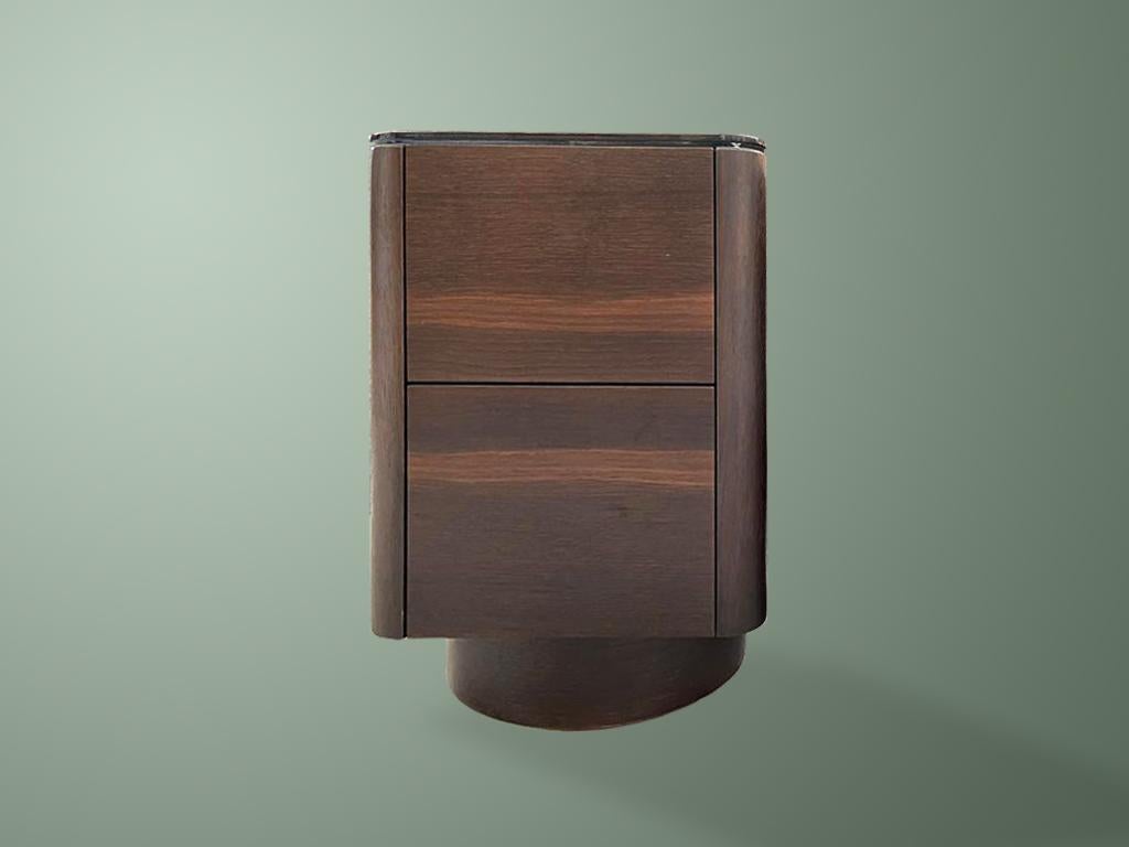 Bedside table with two push to open drawers.

The table is entirely wrapped in wengé veneer with top in smoked glass. 

As with all our furniture, this bedside table is made to order and is therefore highly customisable, including in size and