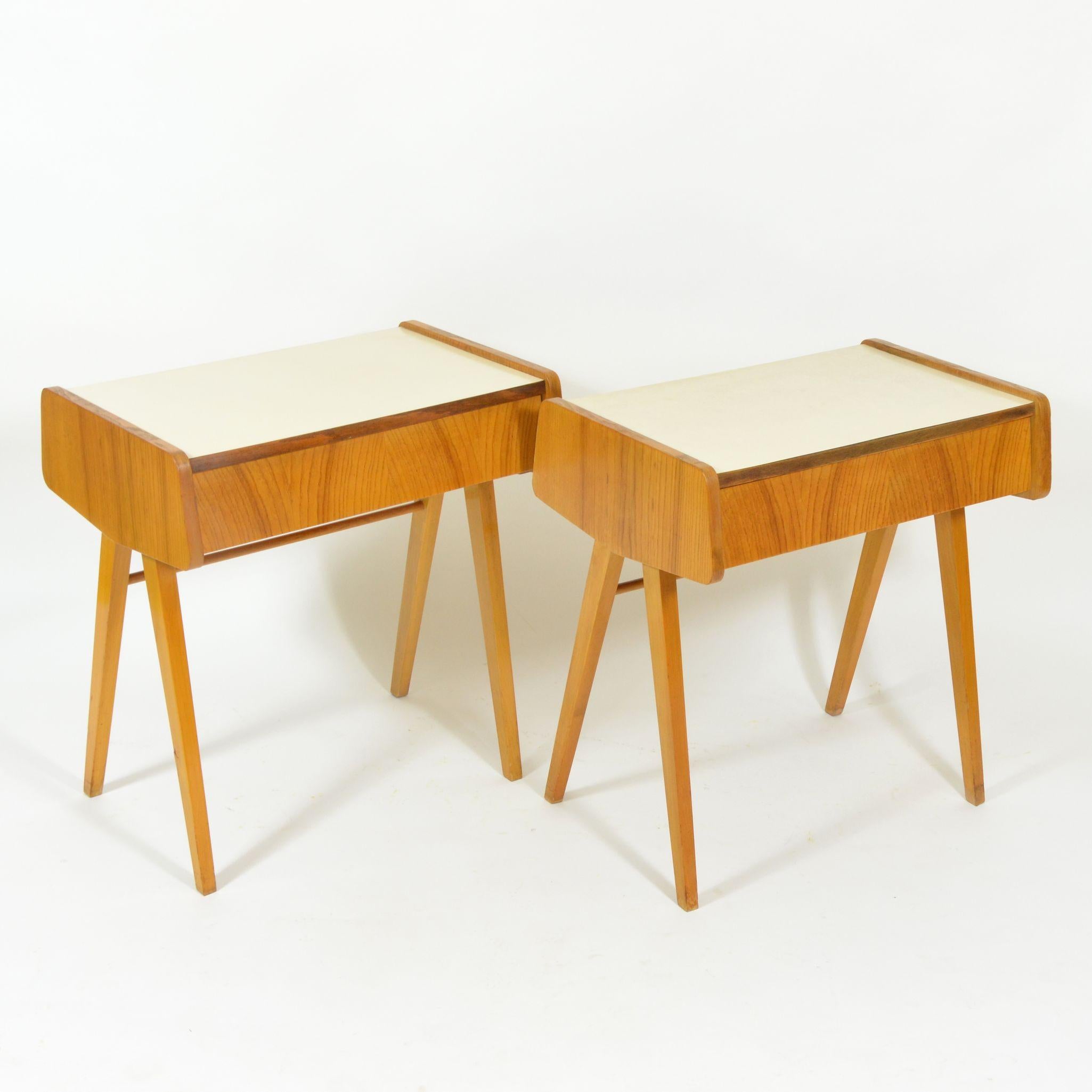 This pair of wooden bedside tables features white Formica tops. One of the pieces comprises a single drawer, the other one is fixed. In original, but very good condition. Manufactured in former Czechoslovakia by Západoslovenské nábytkárské závody,