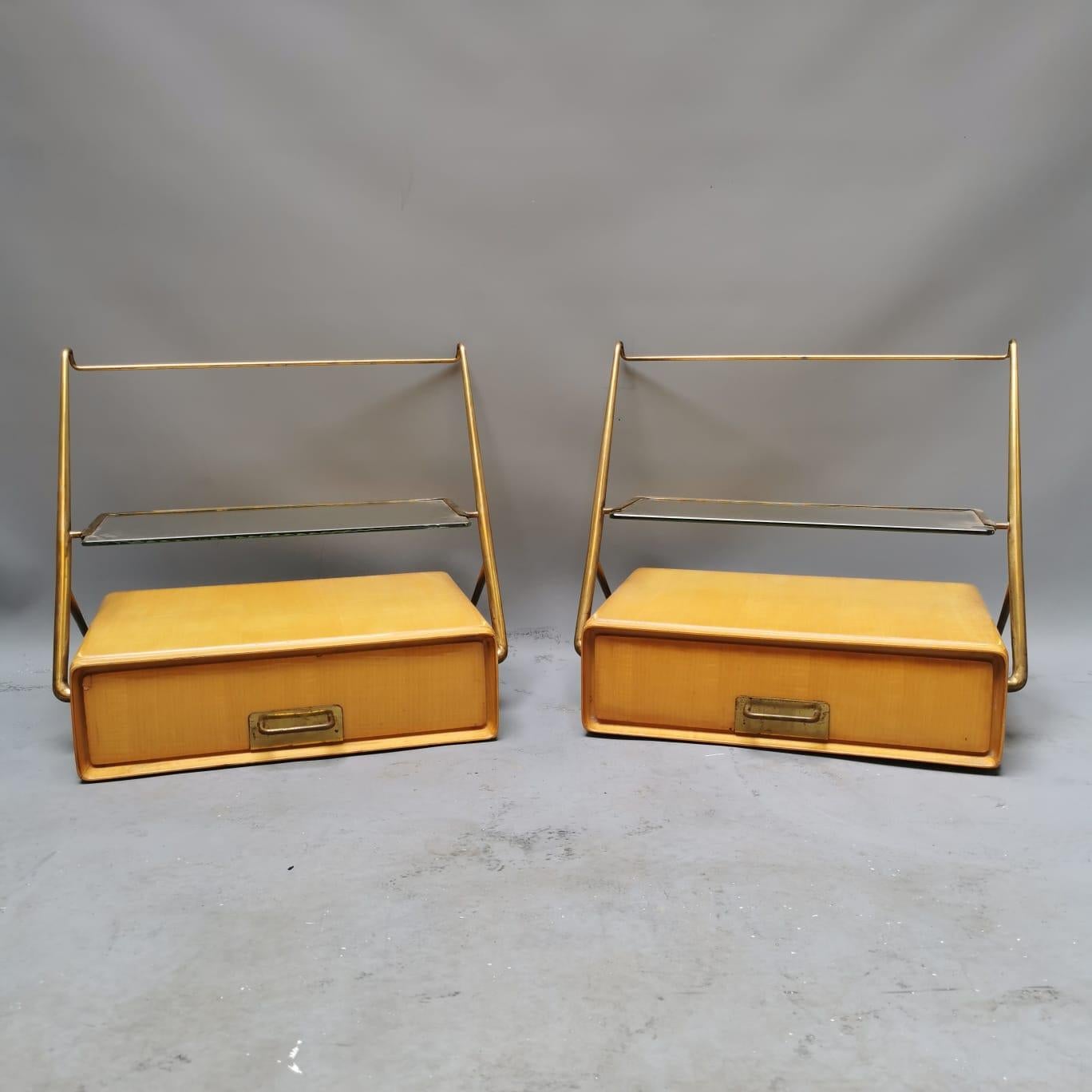 These two bedside represents the perfect e a,ple of great mid-century Italian design. The brass details are incredible and the glass, in very good conditions, make this item so really interesting. These two bedsides are made to be fixed on the wall.