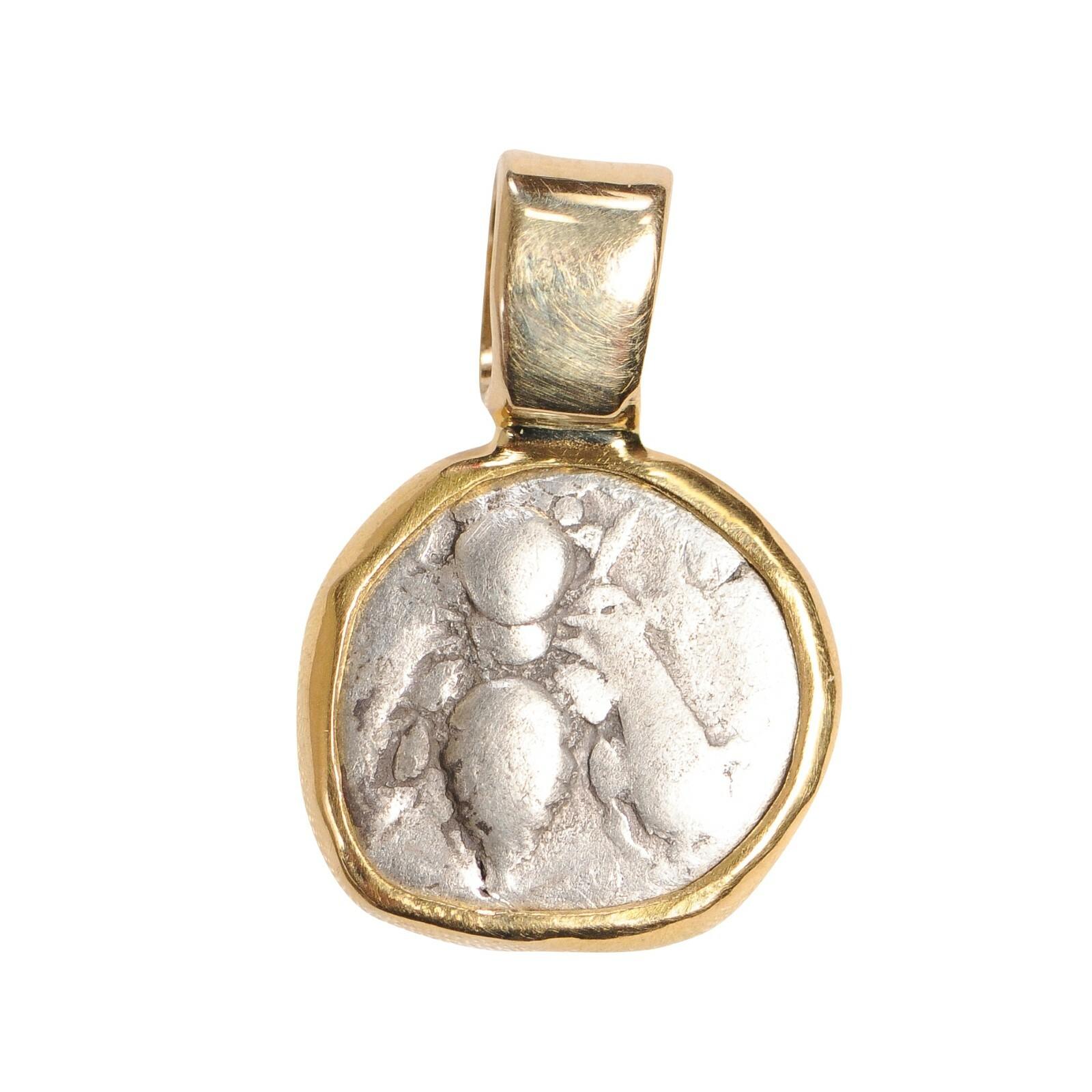 A bee coin pendant hand set in 18k gold. This dainty size pendant with a sweet image of a bee would be a wonderful adornment for a necklace or bracelet . This coin is from ancient Greece. Measurement is .5