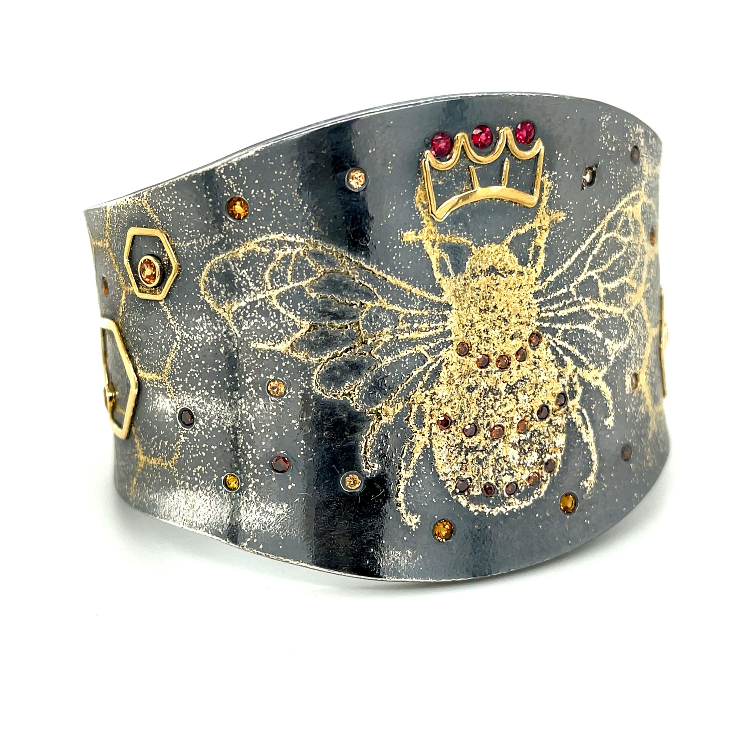 A cuff bracelet made with oxidized sterling silver, 24K, 22k and 18k yellow gold with 1.74 ct. of diamonds and colored stones.(There are .28ct. of Cognac Diamonds,.72ct. of Spessartite Garnets,.24ct. of Citrine,.20ct. of Orange Sapphires and .30ct.