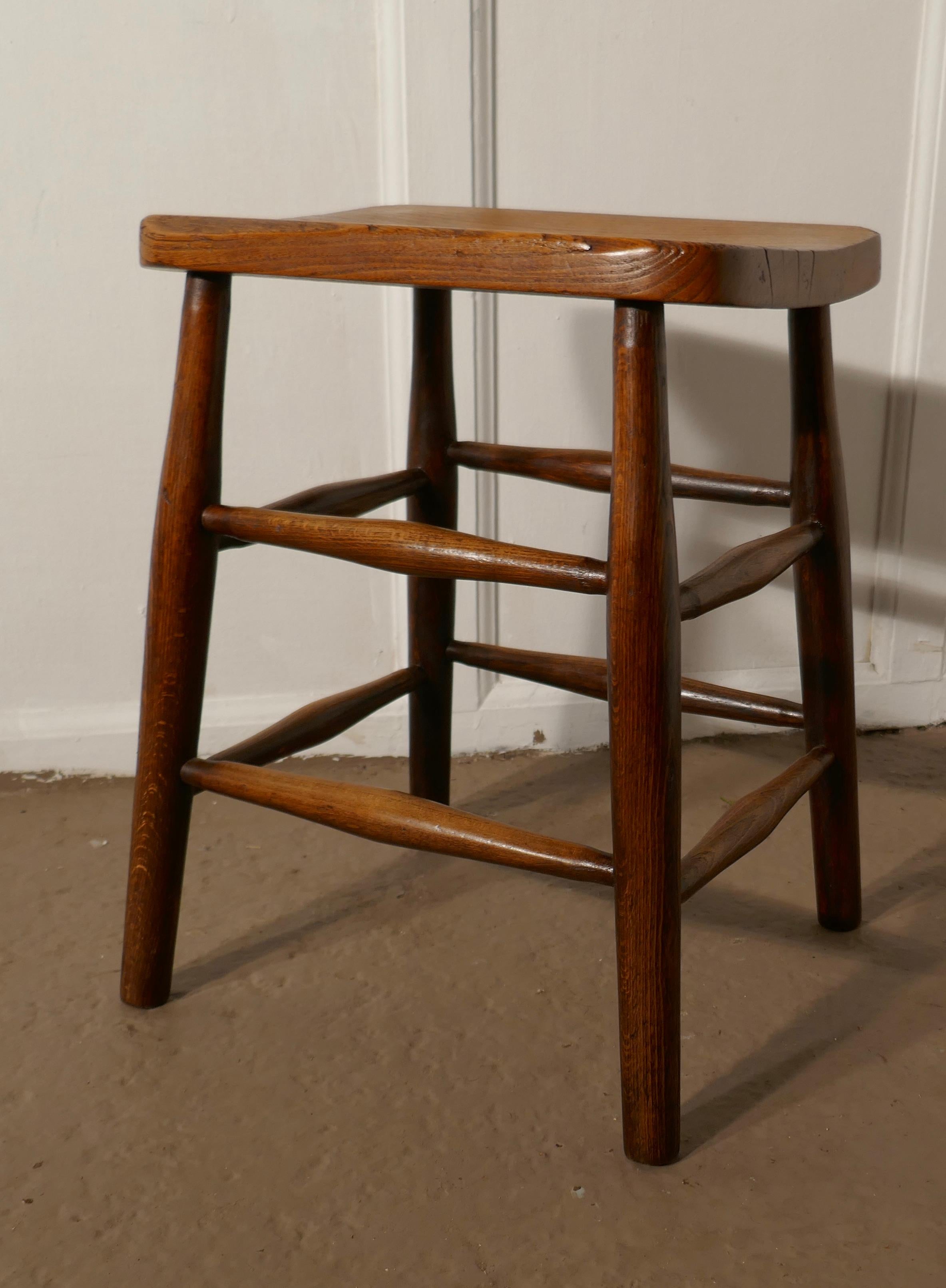 Beech and elm farmhouse kitchen stool

This is a good chunky piece, it has a 1.5” thick elm seat with a carrying handle in the centre and turned beech legs with double stretchers 
The stool is in good sound condition, and has an aged patina
 The
