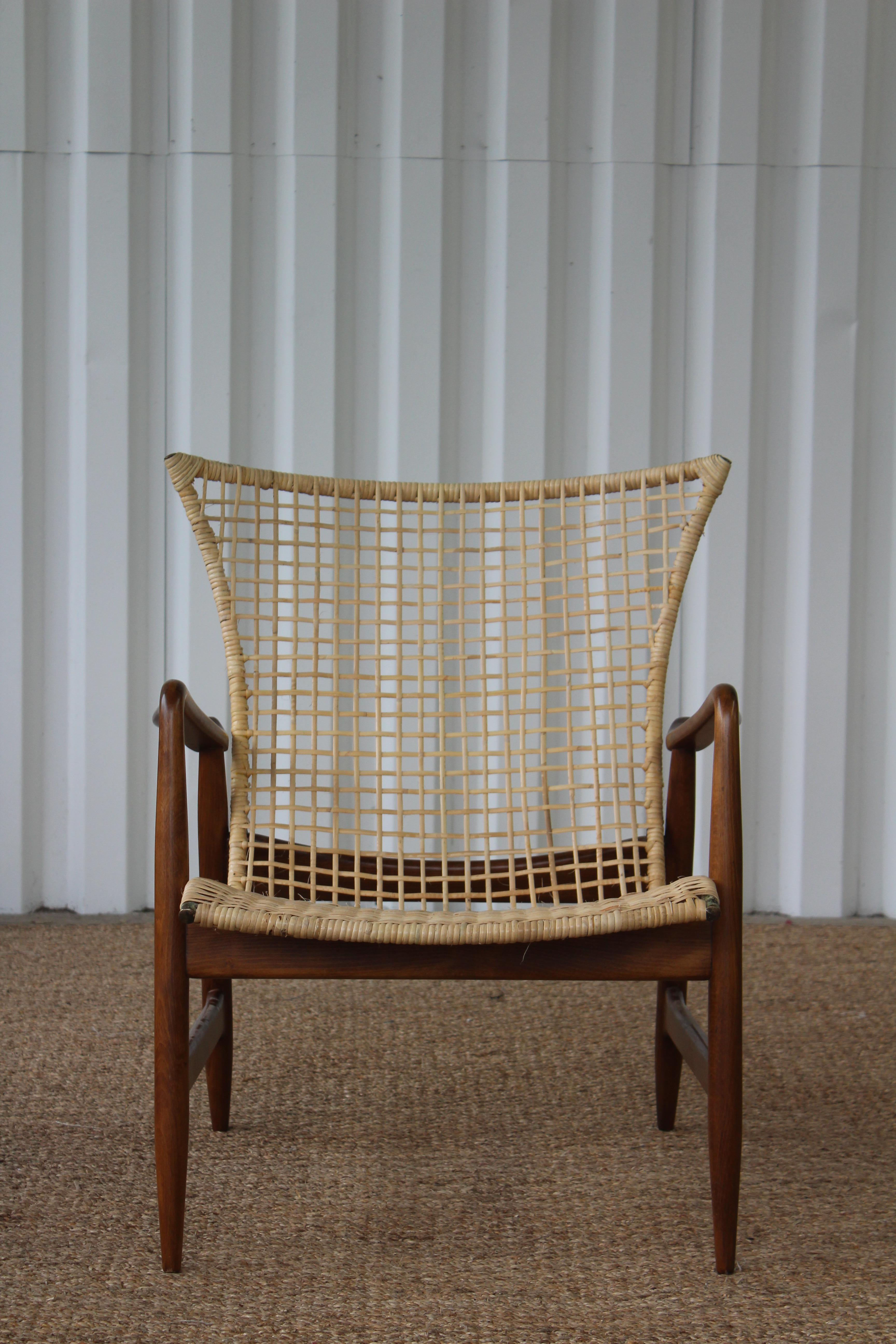 Beechwood and rattan lounge designed by Kofod-Larsen for Selig, Denmark, 1950s. Newly refinished frame and new rattan on the steel frame.