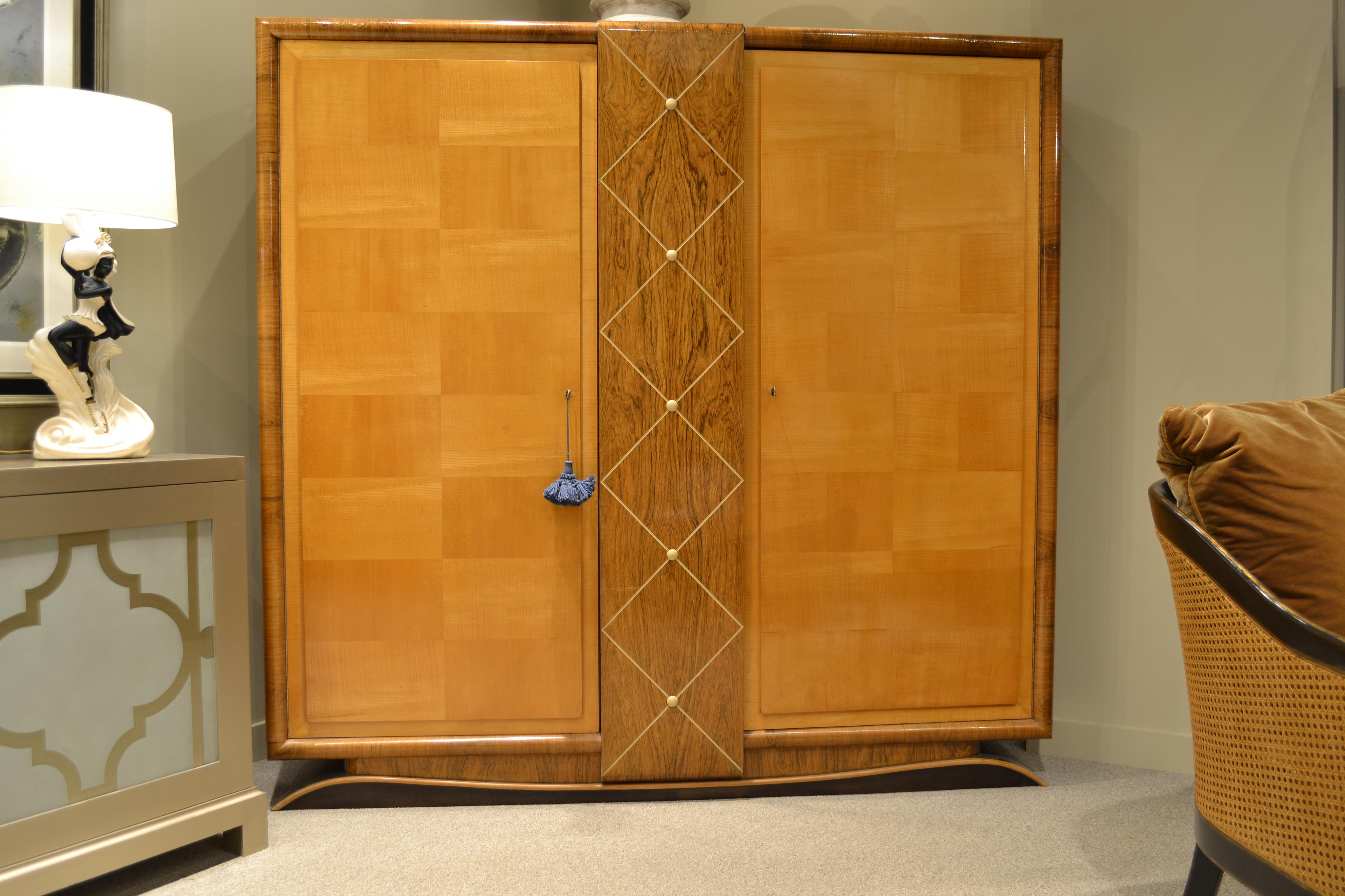 This 1940s cabinet has a shaped walnut, beech and rosewood base supporting a rosewood veneered case and a center vertical panel of the same veneer. This panel is crisscrossed with an ivory incised diamond grid highlighted with ivory colored discs.