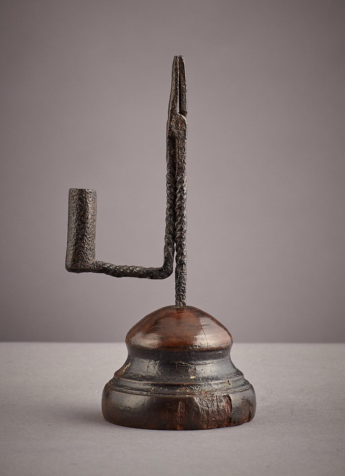 Early 19th century twist stem wrought iron and beech rush nip, English, circa 1800-1820.

The spiral twist stem with pincer action nip and counter weighted arm with candle socket, all set into the original turned Beech base, having original staple