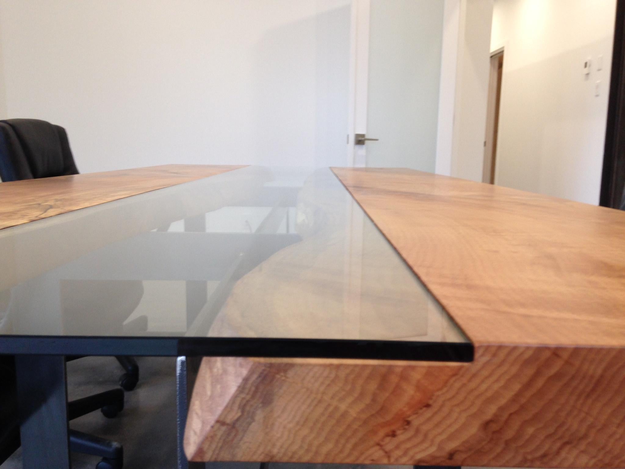 This is a beautiful beech conference table with a central tempered glass on steel legs. We use the live edge facing each other. We let nature design with the curves, cracks and holes and our role is to protect the beauty by offering you one of the