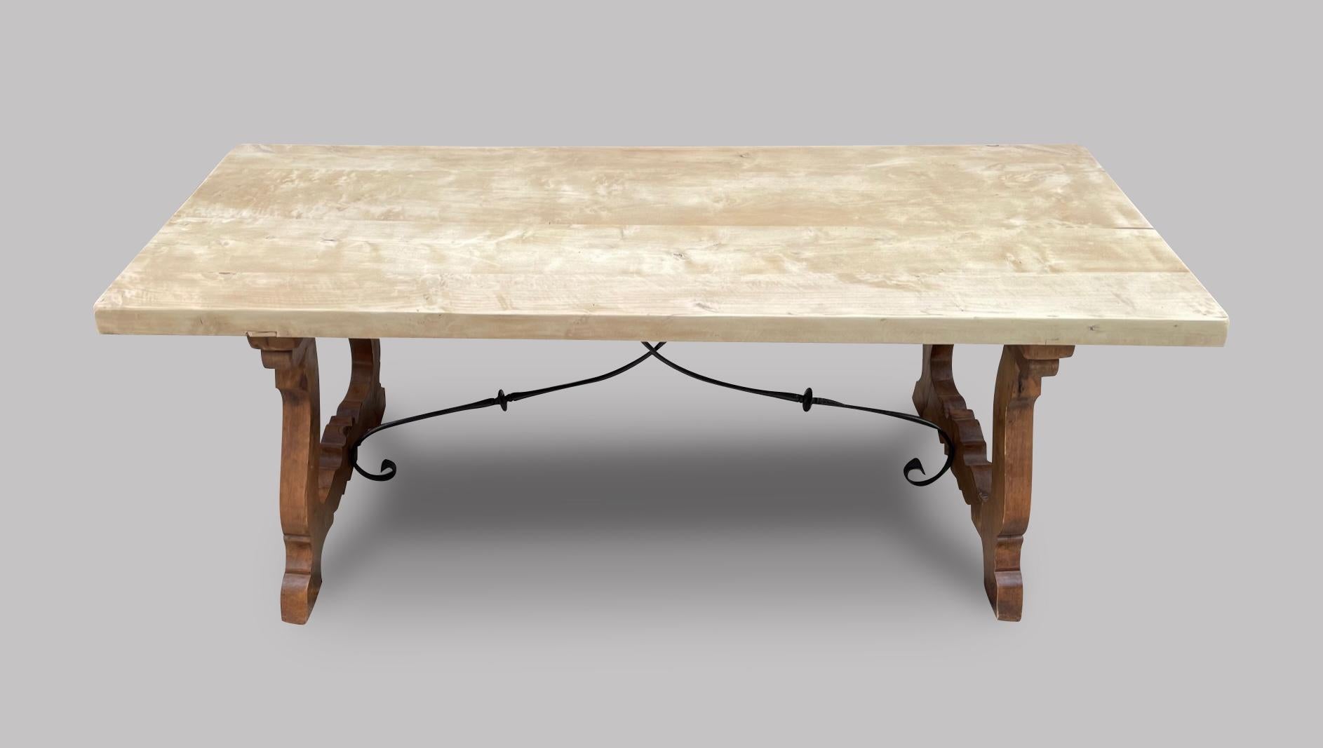 An attractive beech farmhouse/refectory table with a bleached top probably Spanish with large carved out splayed legs united by a metal stretcher.

Measures: length 200 cm, depth 77 cm and height 77 cm.