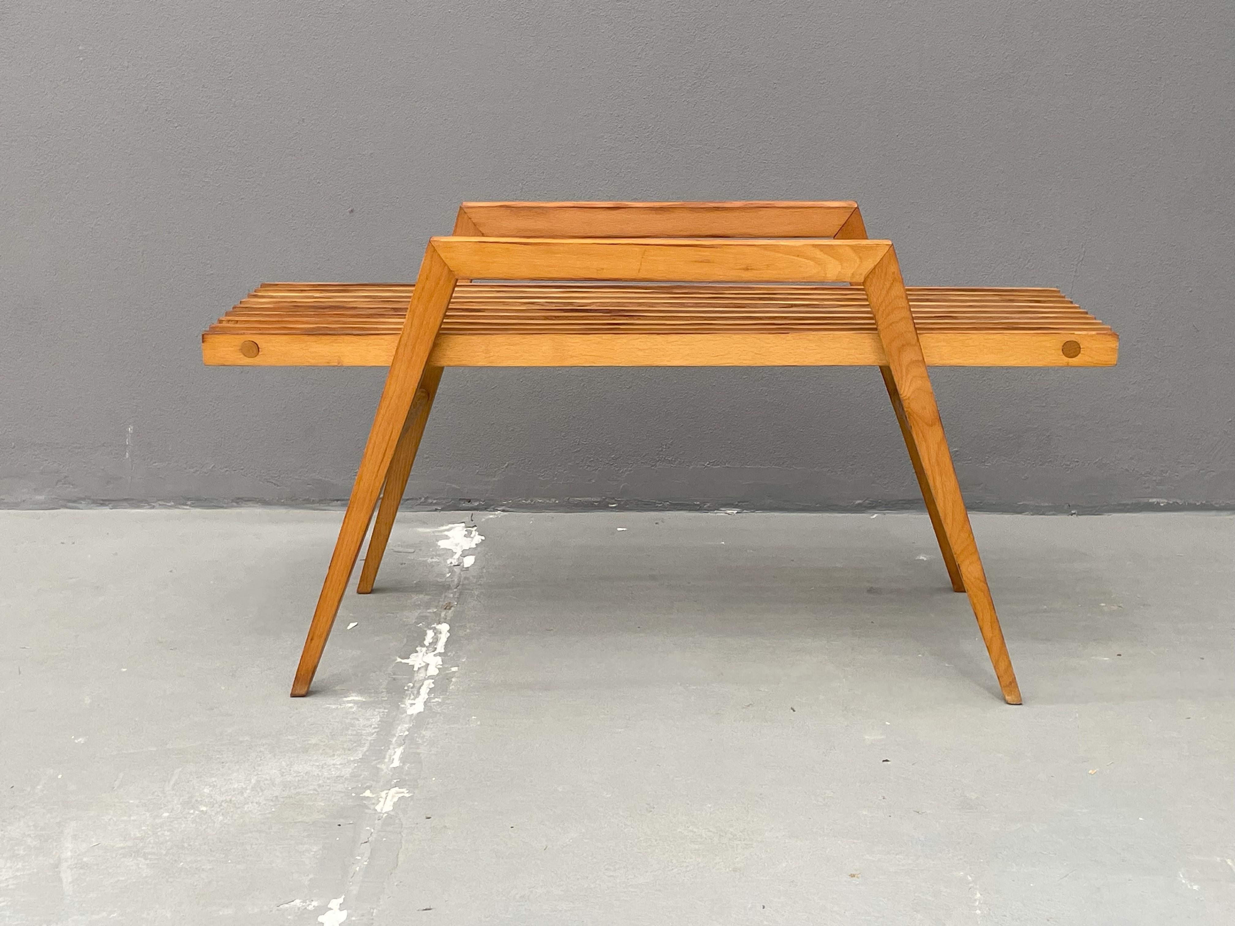 Cette table basse au design minimaliste associe un plateau en verre à un cadre en bois de hêtre. Le plateau en verre transparent lui confère un aspect léger, tandis que la structure en bois lui assure stabilité et durabilité. Il convient aux