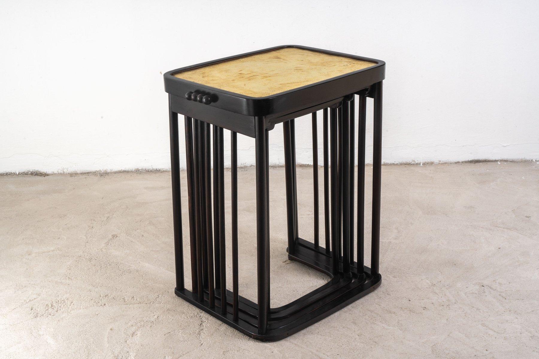 This exquisite set of nesting tables, designed by the renowned Josef Hoffmann and produced by Jacob & Josef Kohn in Vienna around 1905/06, is a testament to the Art Nouveau movement. Crafted from beech wood and featuring inlaid hammered brass tops,