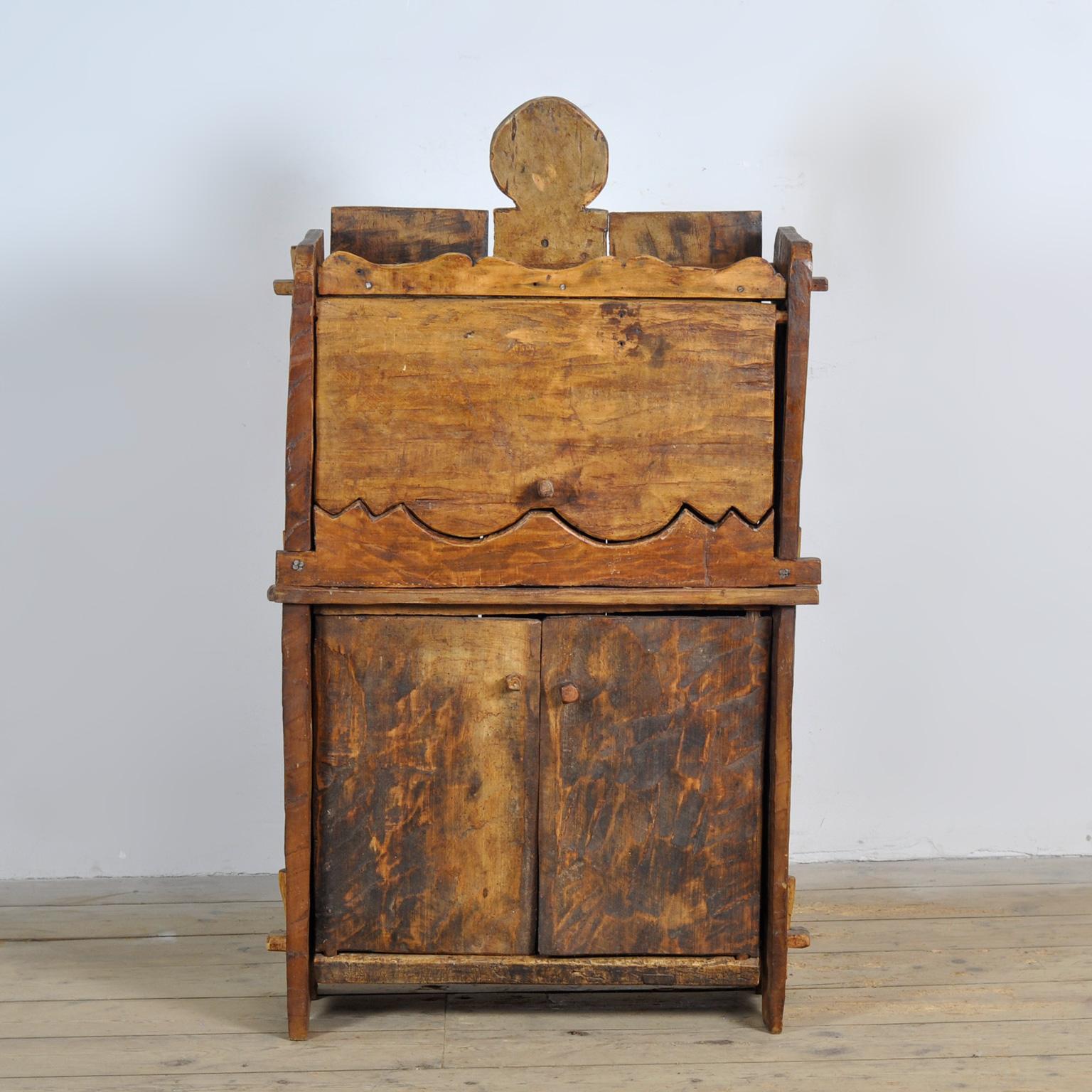 Rustic Wabi Sabi cabinet made of solid beech in Italy, circa 1800. This cabinet offers storage space for various items. It features a flap at the front and storage space behind the two doors. Ideal as a hallway cabinet. This piece is in good