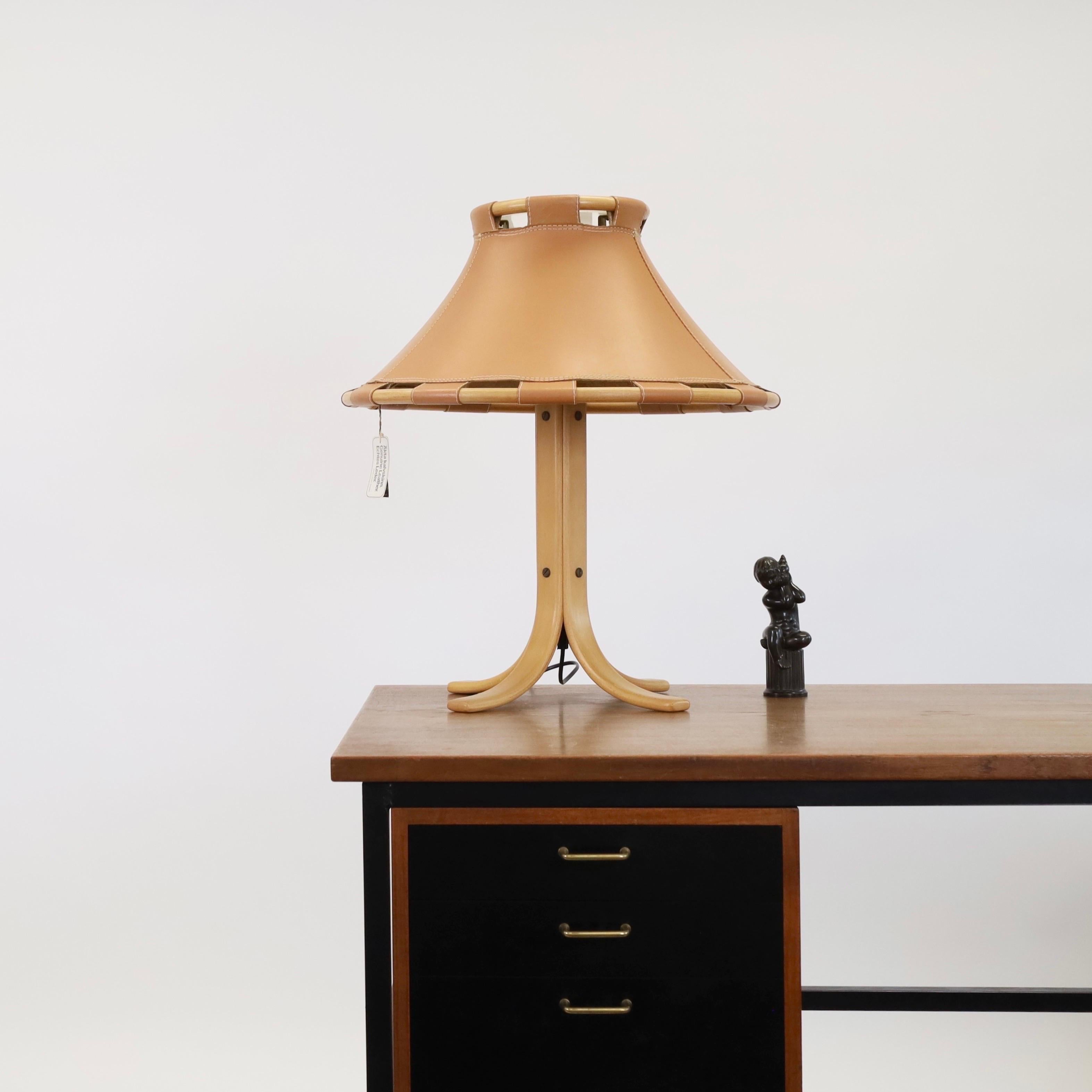 A substantial beech wood and leather desk lamp by Anna Ehrner for Ateljé Lyktan. A Nordic vibe to any beautiful space.   

* A bent beech wood desk lamp on four legs with a large leather shade on a bamboo frame.
* Designer: Anna Erhner 
* Model: