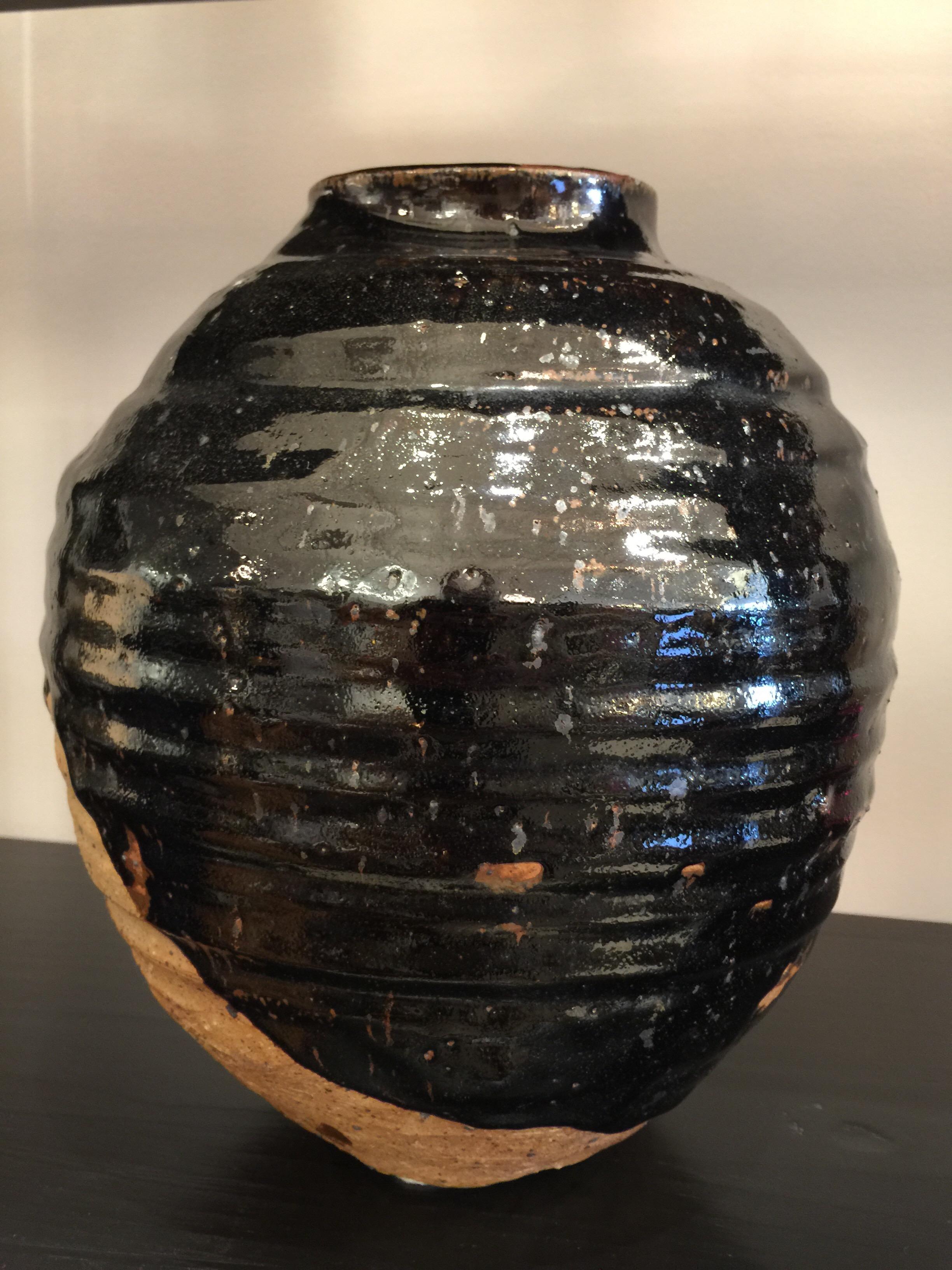 Il s'agit d'un vase en faïence naturelle émaillée noire extrêmement bien fait et élégant.