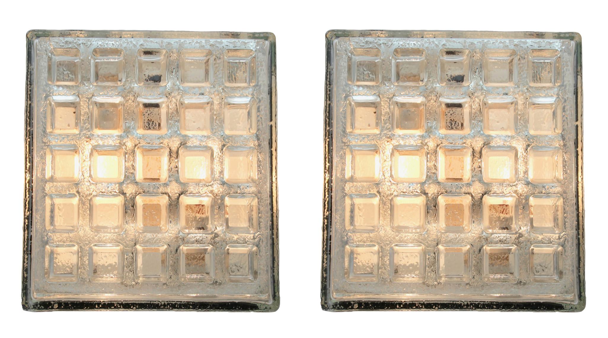 These flat mounting lights were made by the German lighting studio, BEGA, and manufactured in the 1970s. They have an Industrial style and feature a textured square clear glass cover by Glashütte Limburg with a indented grille motif, and are mounted